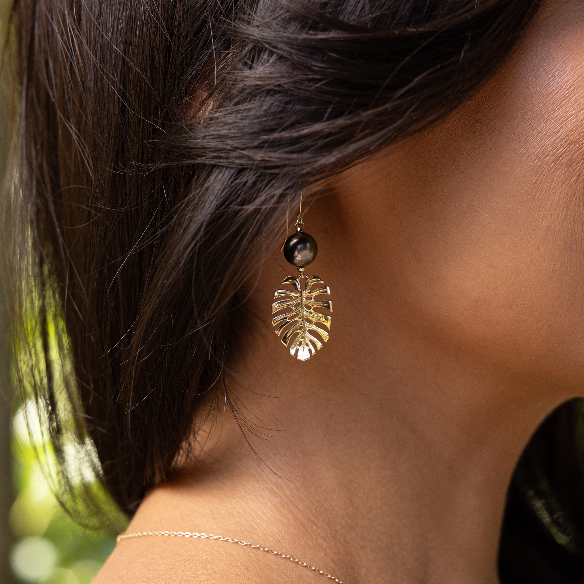 23mm Monstera Tahitian Black Pearl Earrings in Gold on woman's ear