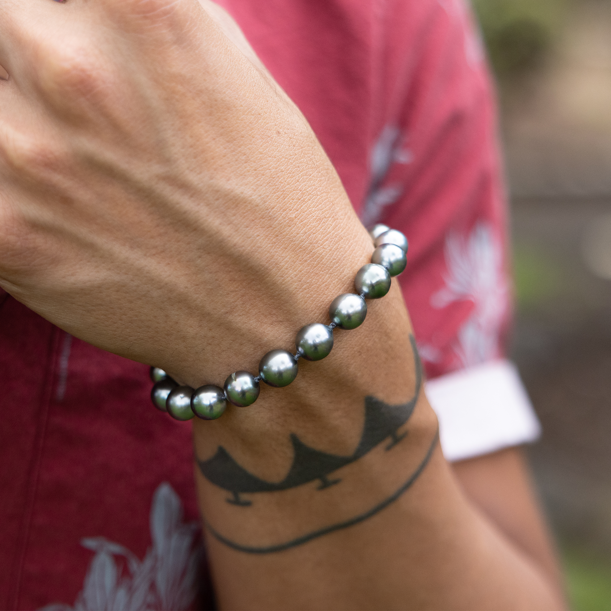 Close up of a 7.5-9" Adjustable 8-10mm Tahitian Black Pearl Bracelet in Gold on a wrist