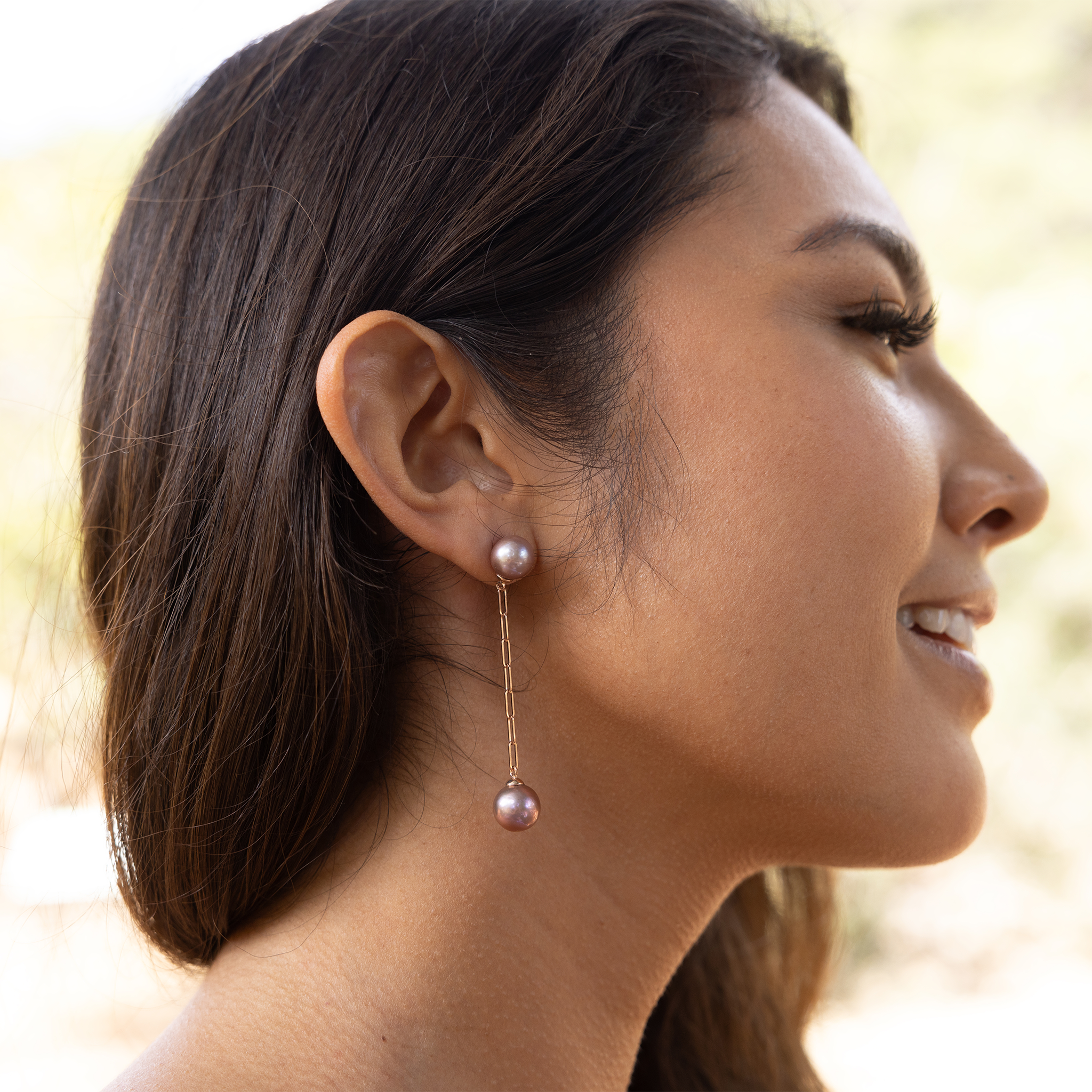 9-10mm Freshwater Ultraviolet Pearl Paperclip Chain Earrings in 14k Rose Gold on a woman outdoors