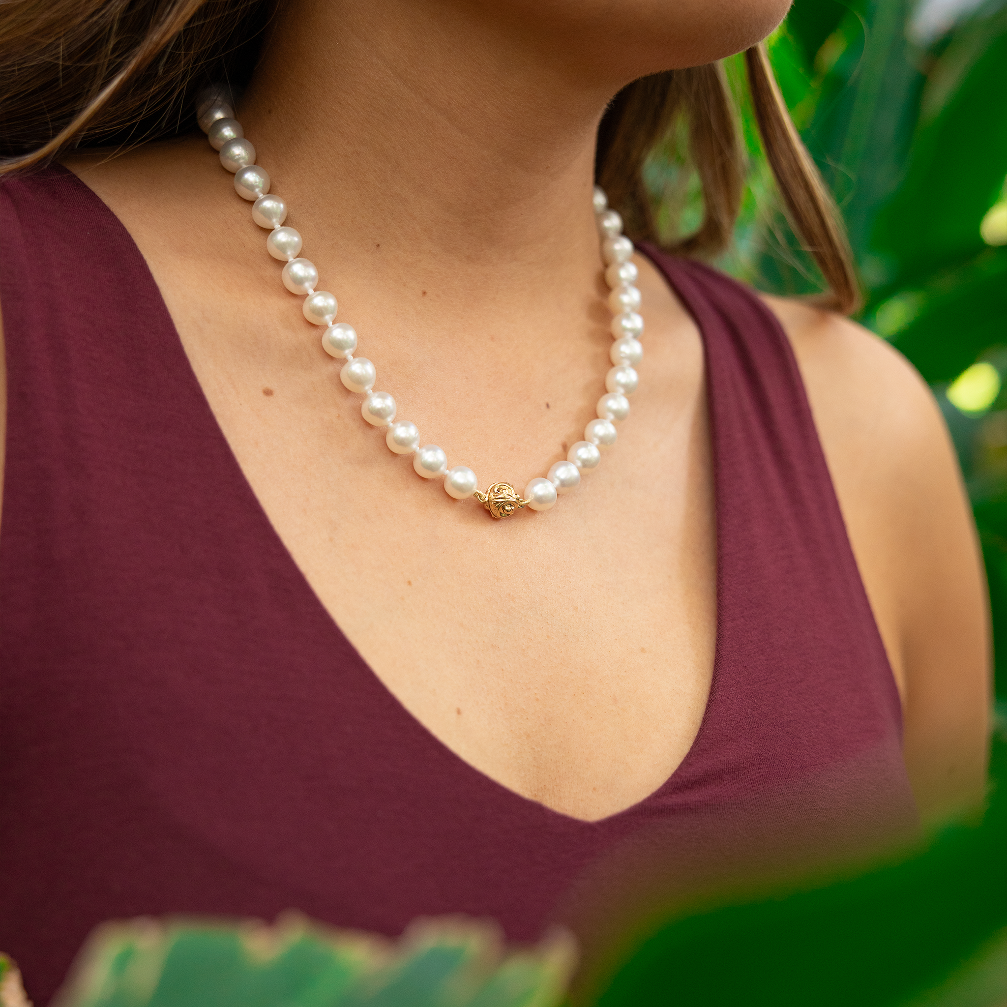 Close up of an 18-19" 9-10mm South Sea White Pearl Strand with Magnetic Clasp in Gold on a woman's neck
