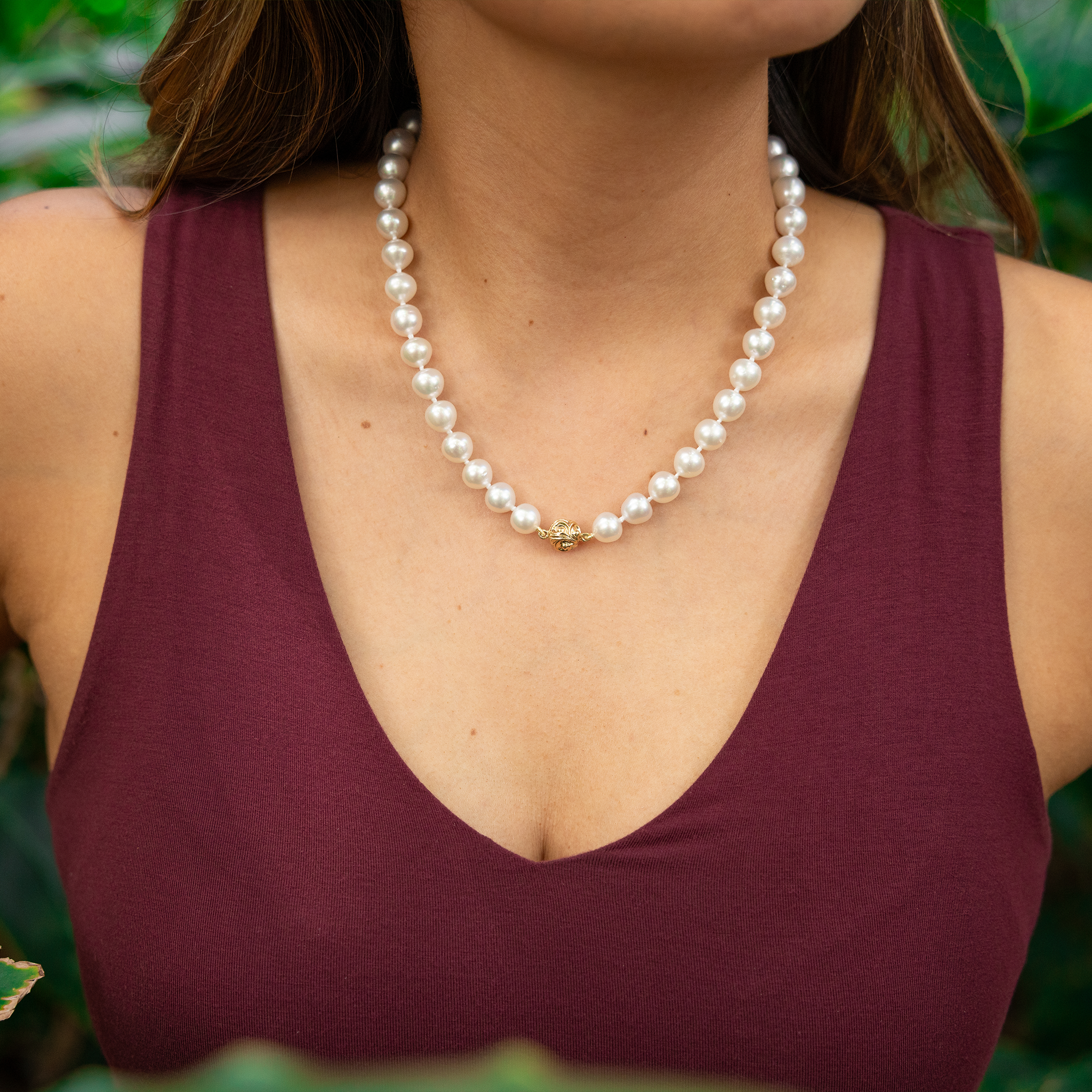 Close up of a woman's chest wearing an 18-19" 9-10mm South Sea White Pearl Strand with Magnetic Clasp in Gold