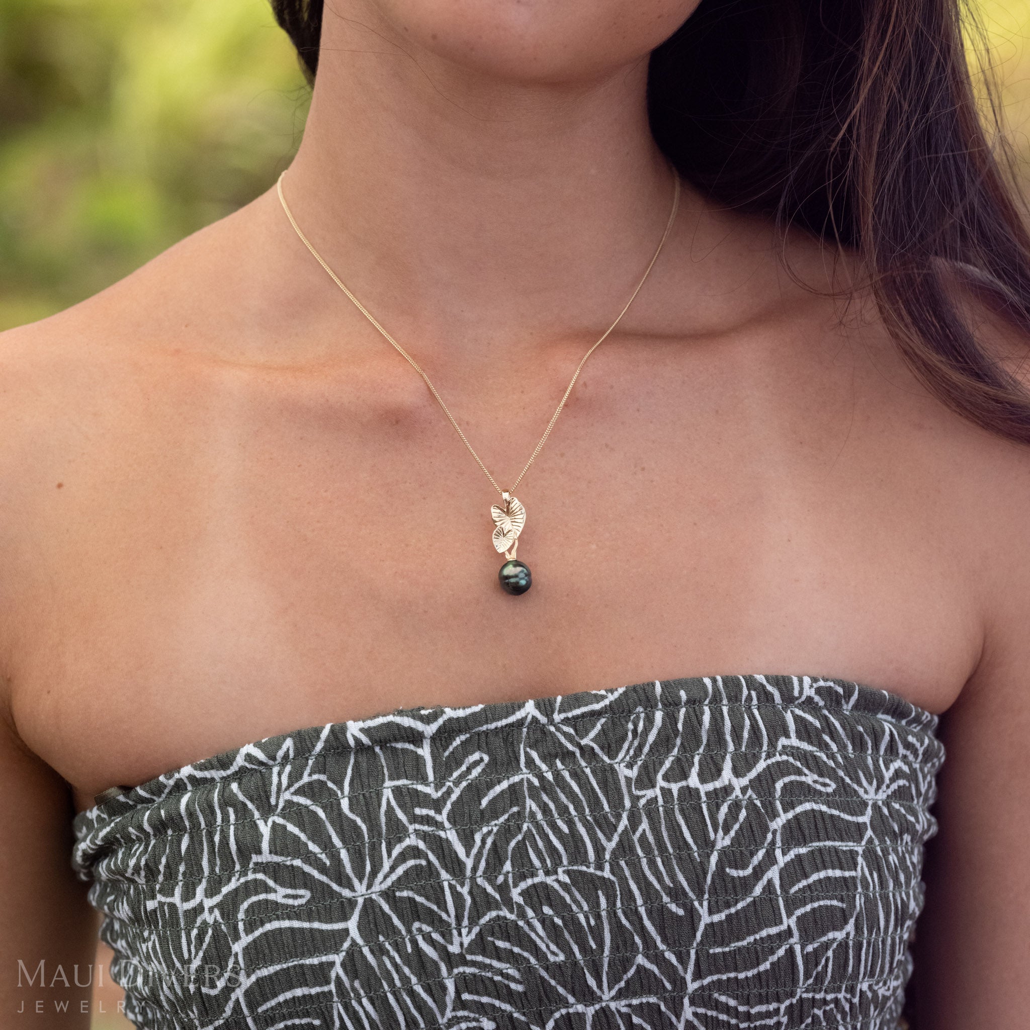 Close-up of a 14k Gold Kalo (Taro) Pendent with a Black Tahitian Pearl.