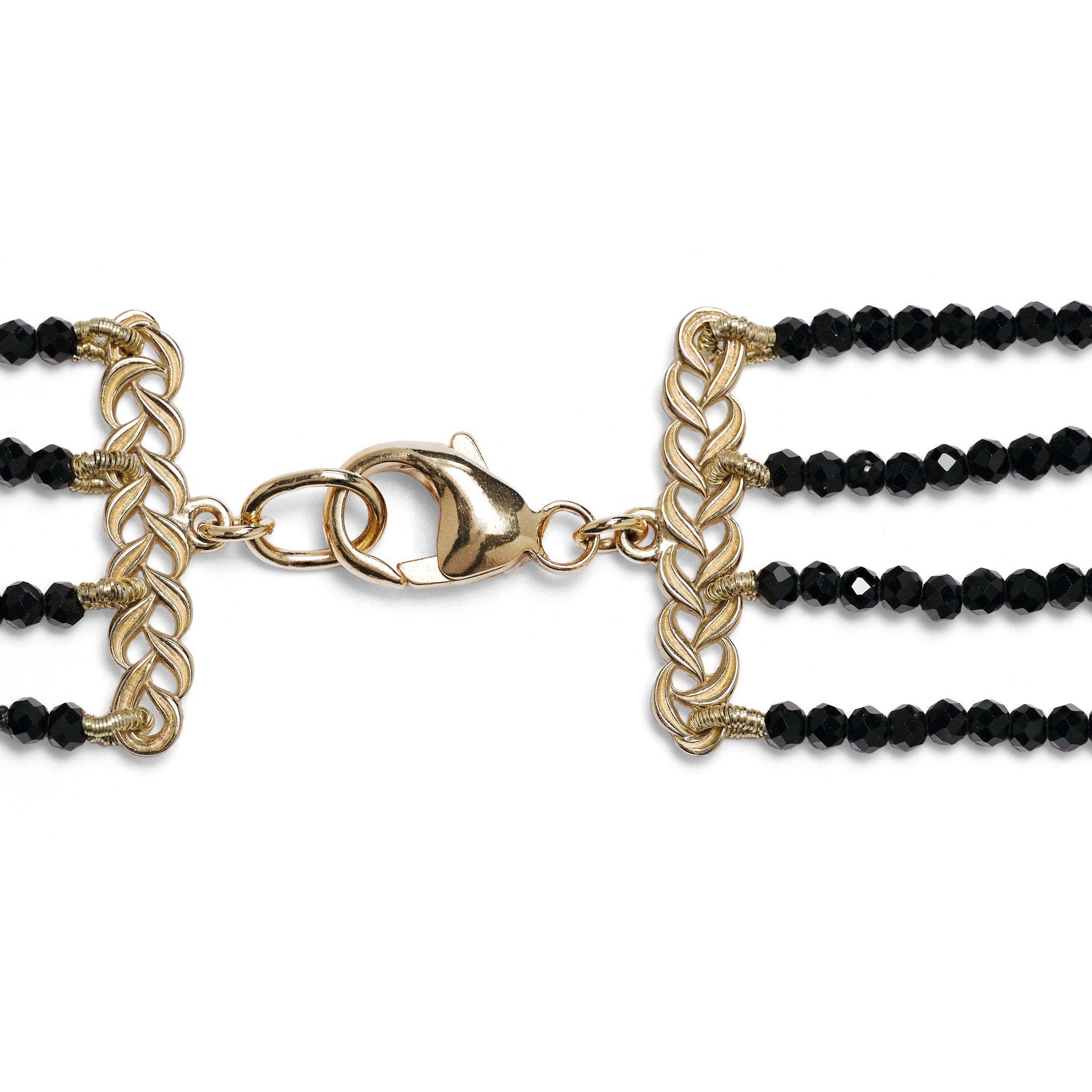 Detail shot of a gold lobster claw clasp with black spinel necklace attached on each side