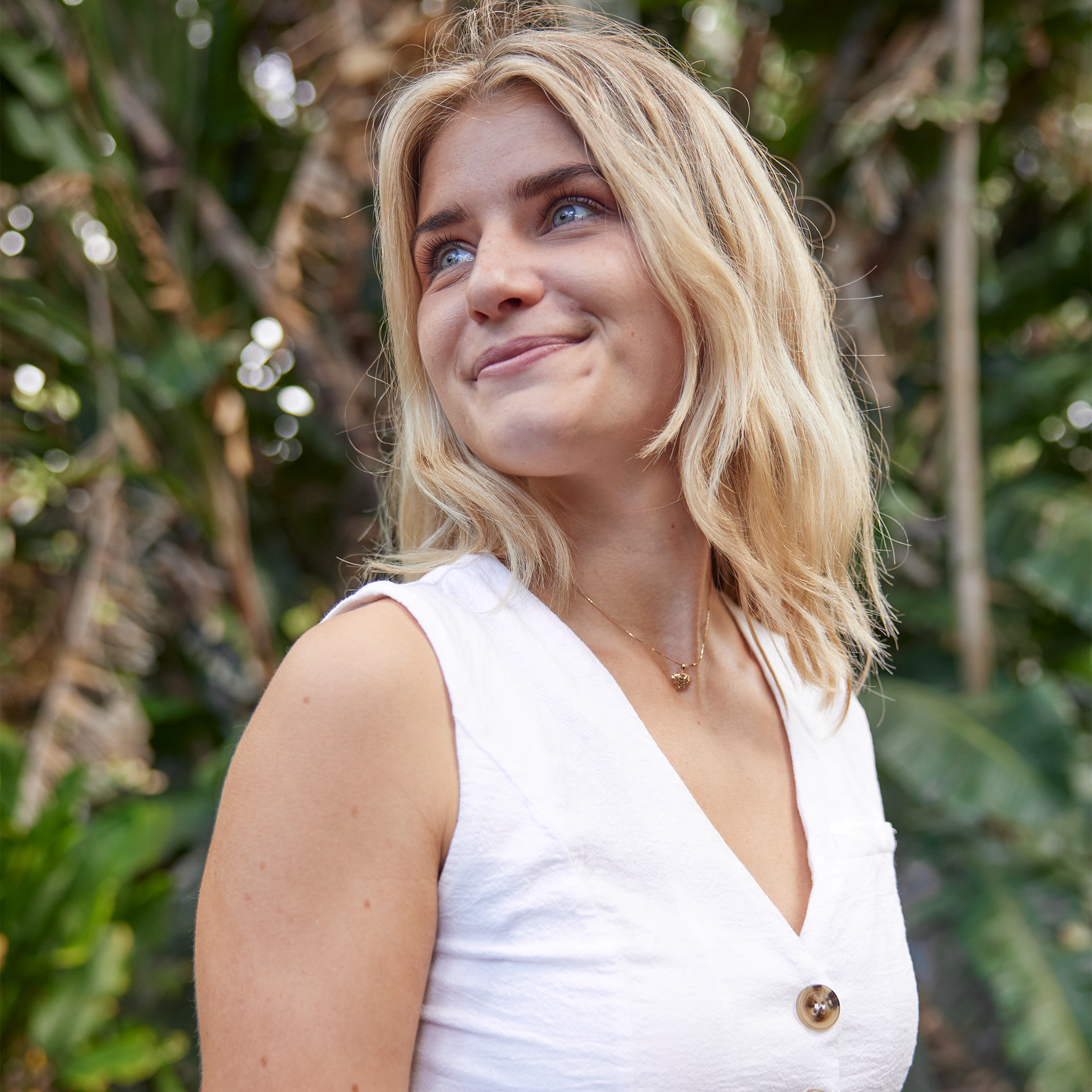 Woman smiling with nature background wearing Aloha Heart Pendant in Gold - 9mm