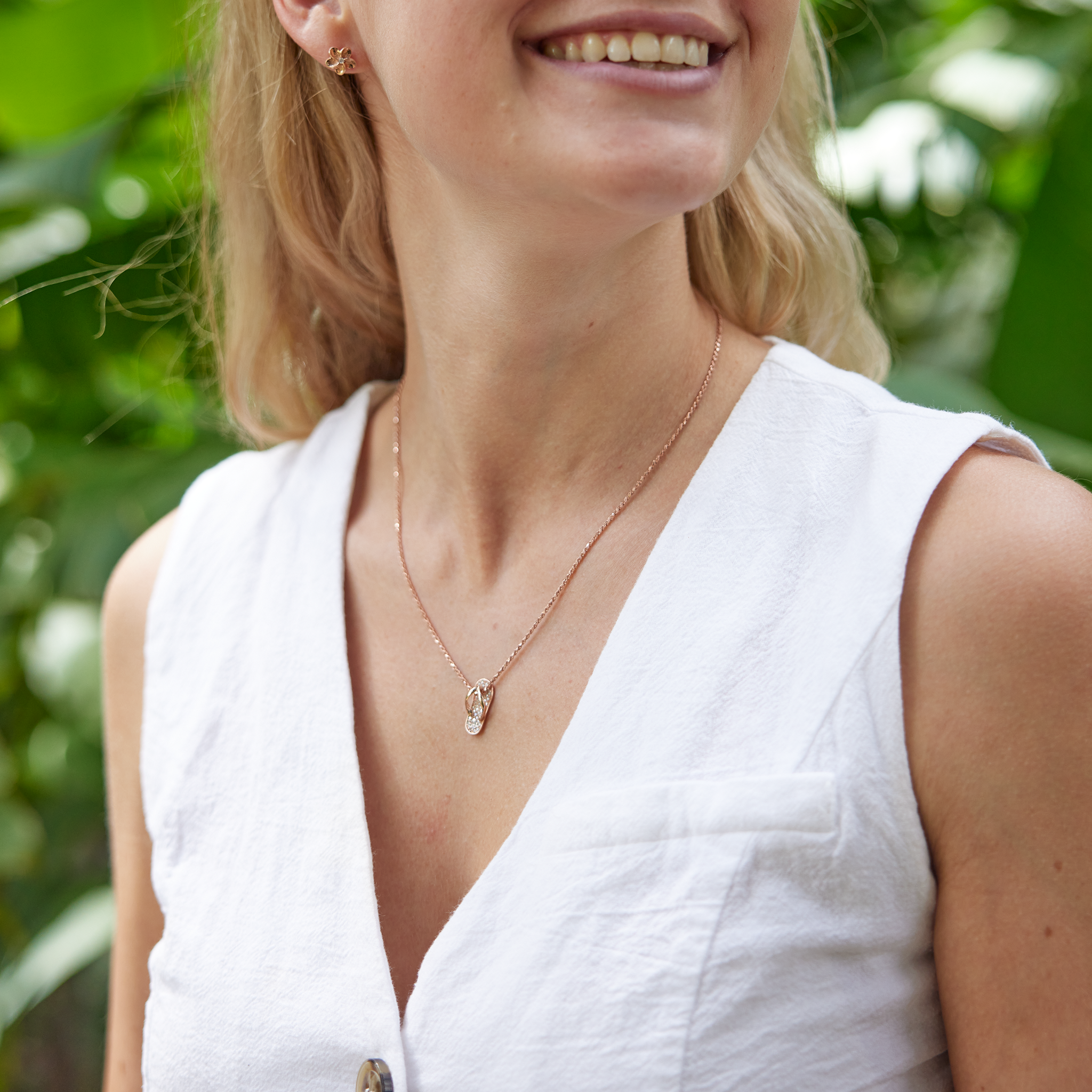 Woman in white shirt wearing Slipper Pendant in Rose Gold with Diamonds - 18mm with nature background