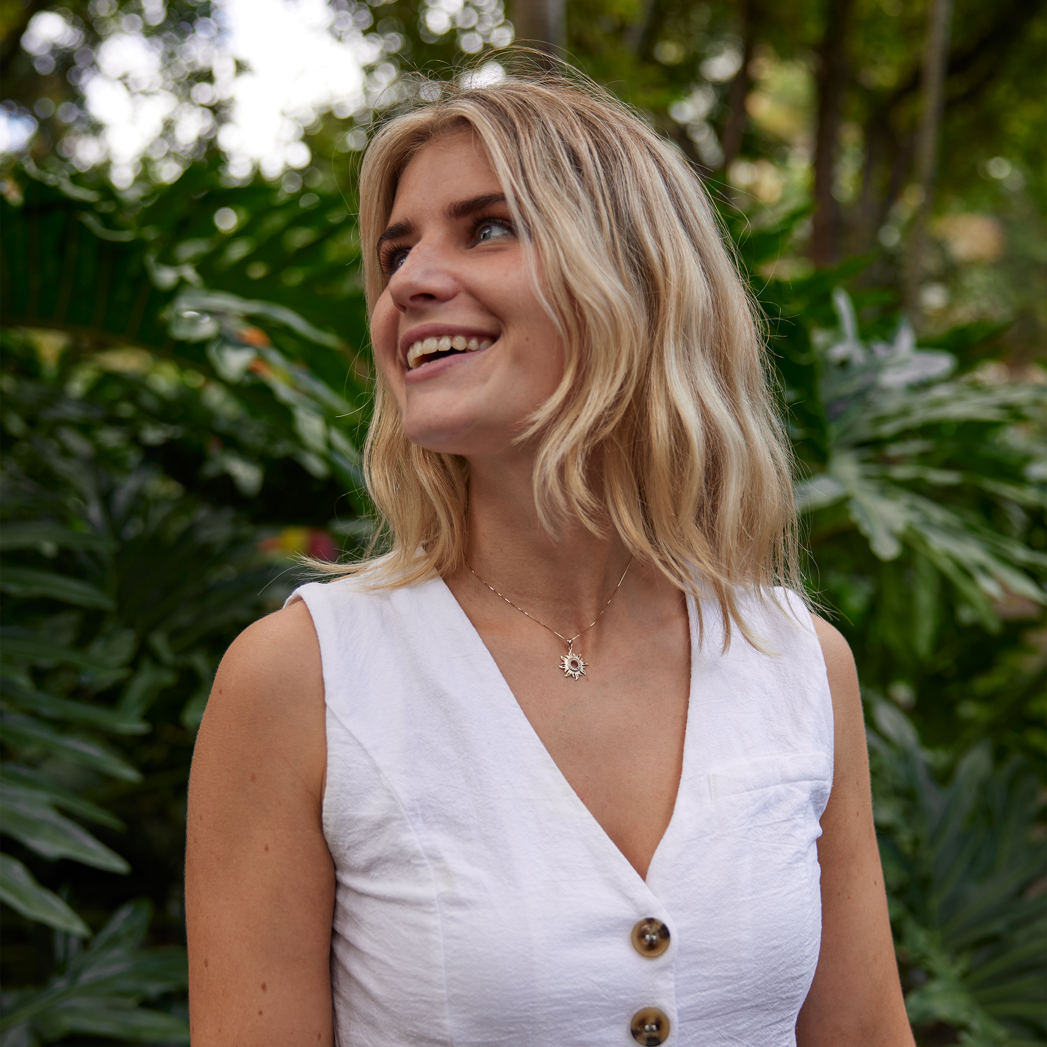Woman in garden wearing Sun Pendant in Gold with Diamonds - 17mm
