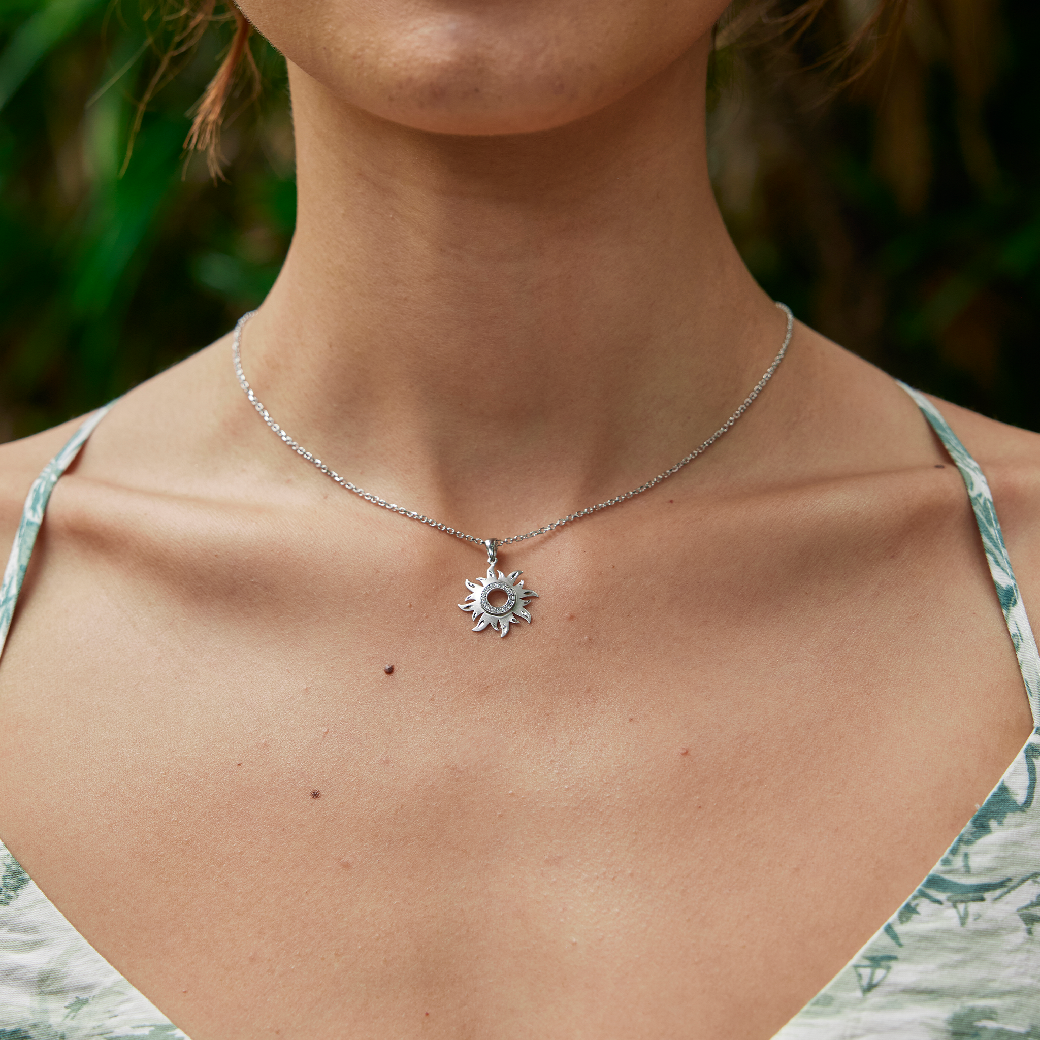 Woman's neckline featuring white gold Sun Pendant with diamonds on cable chain