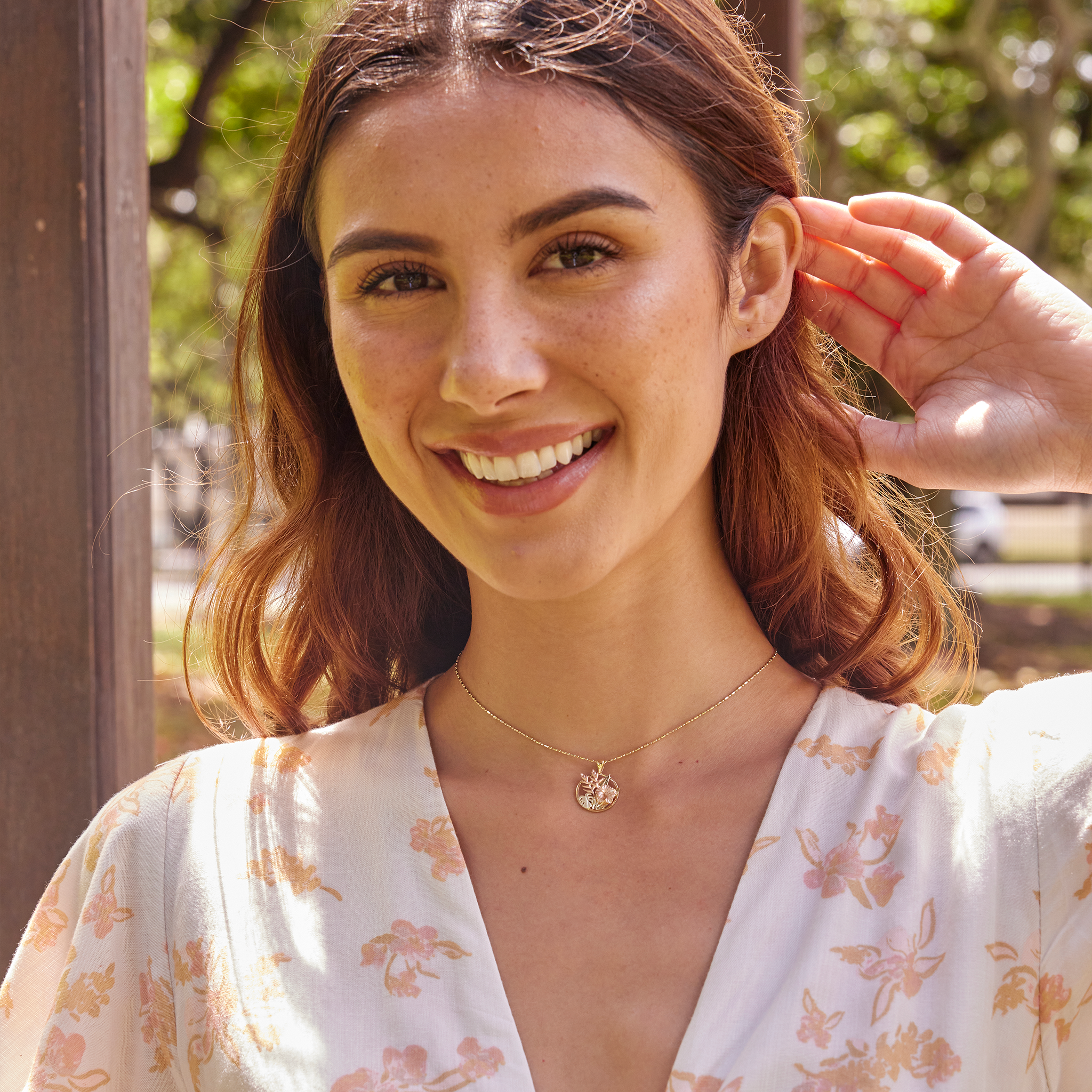Woman wearing Hibiscus, Heliconia and Monstera Pendant in Tri-color gold with diamonds