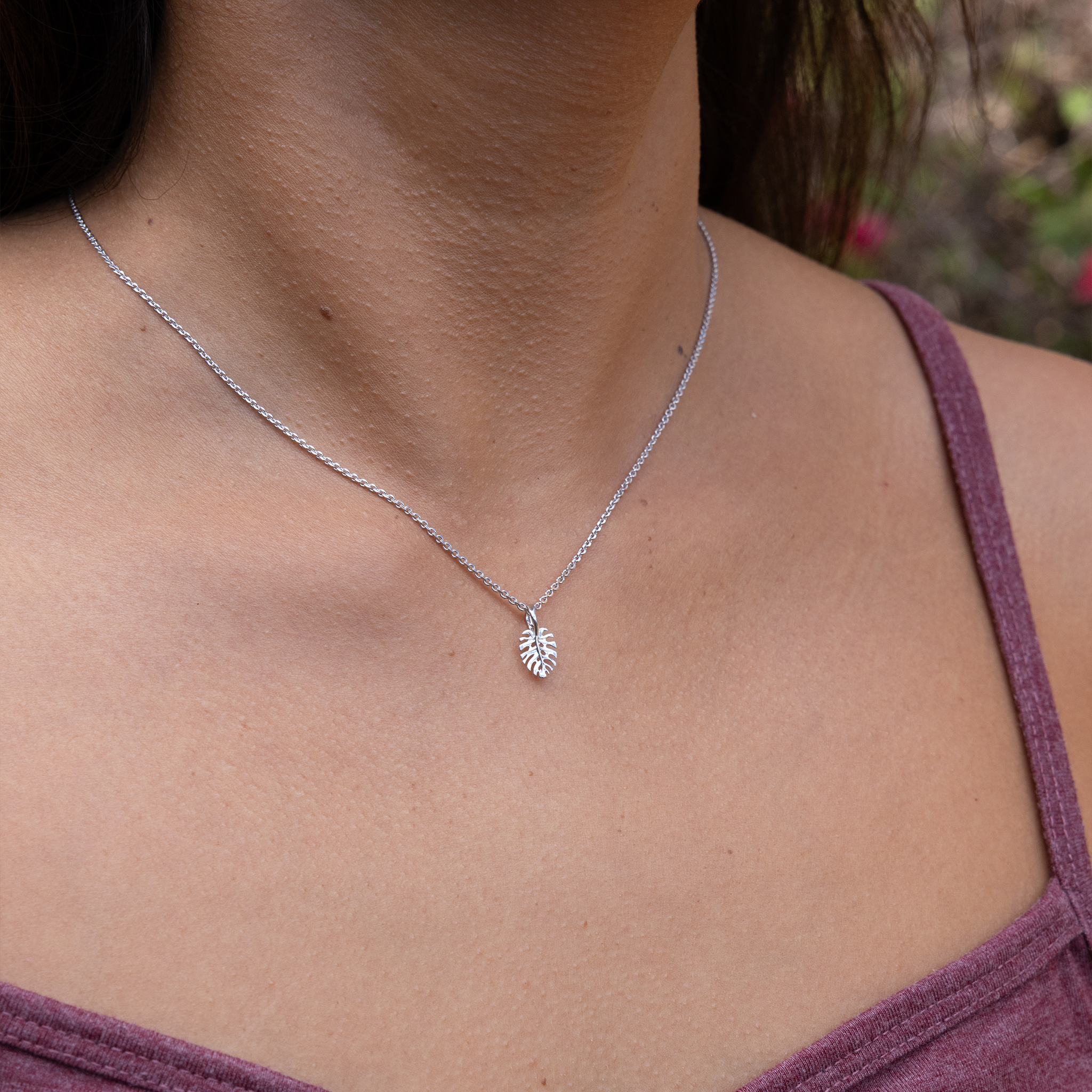 Close up of neckline wearing Monstera pendant in white gold on cable chain