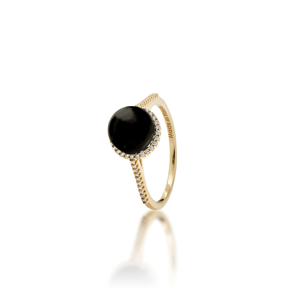 A 14k gold ring set with a high polished 7-7.9mm Round Hawaiian black coral surrounded with a diamond halo, diamond detail on top half of the band, placed on a reflective white surface.
