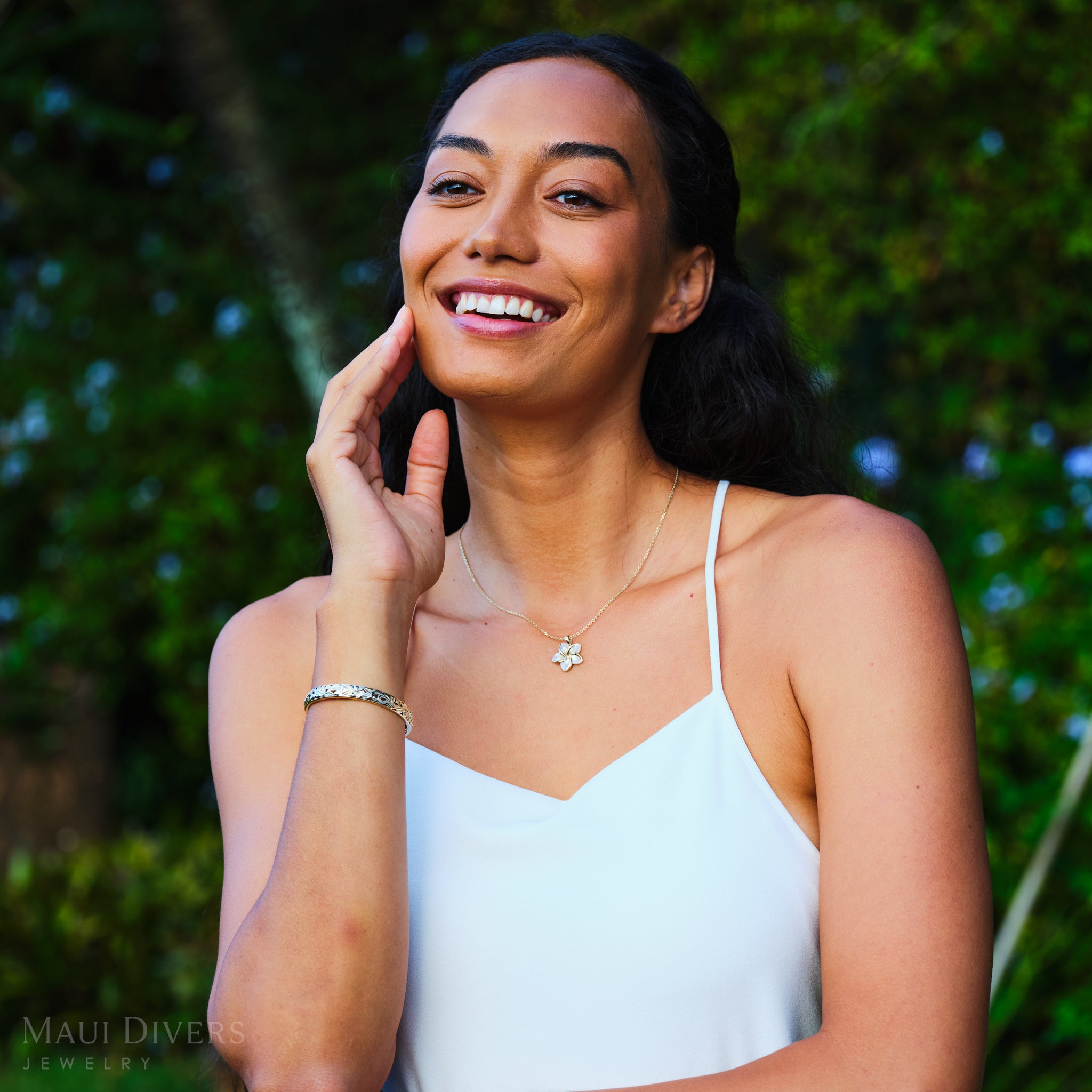Smiling woman wearing Plumeria Mother of Pearl Pendant in 14k Yellow Gold outdoors