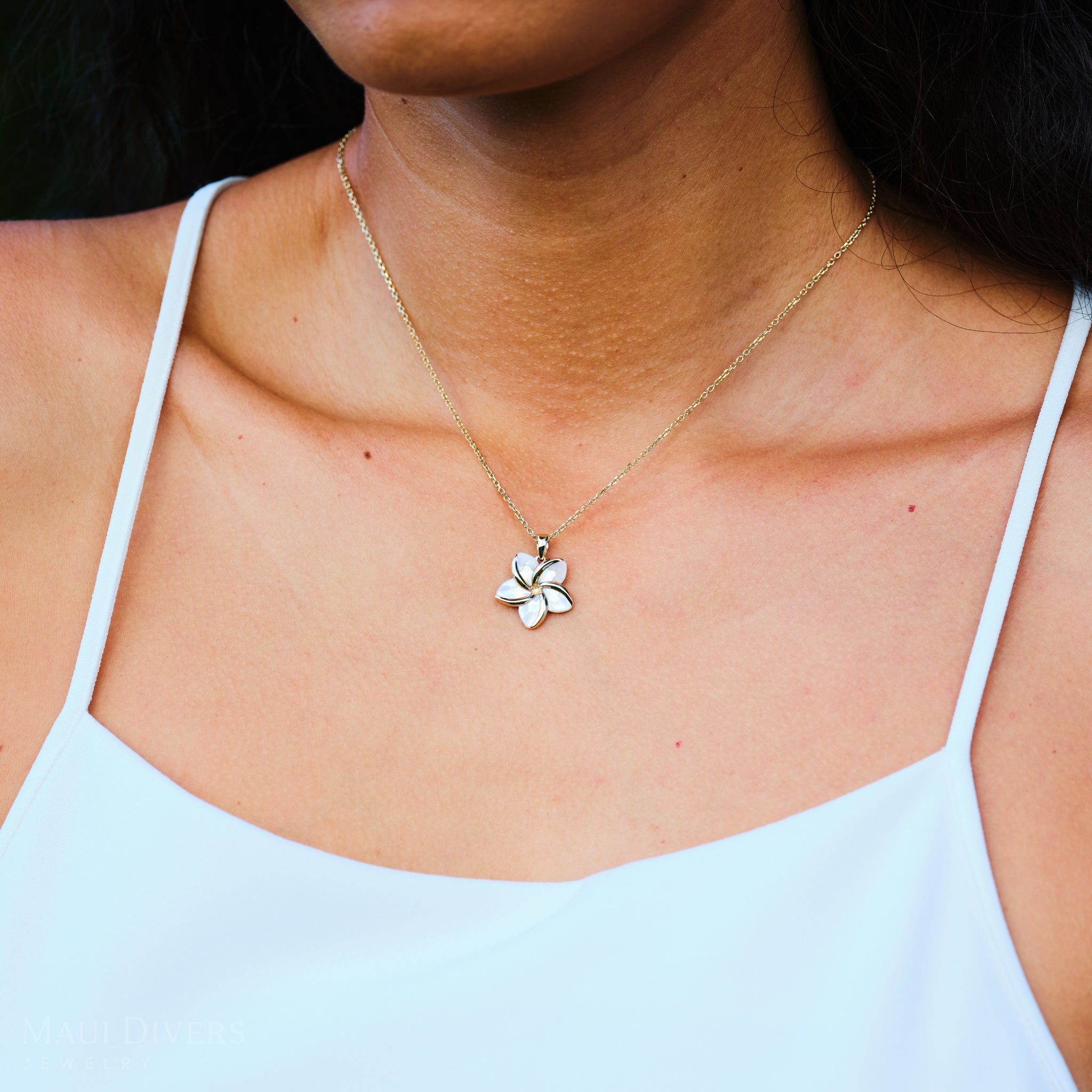 Close up of Plumeria Mother of Pearl Pendant in 14k Yellow Gold on neckline