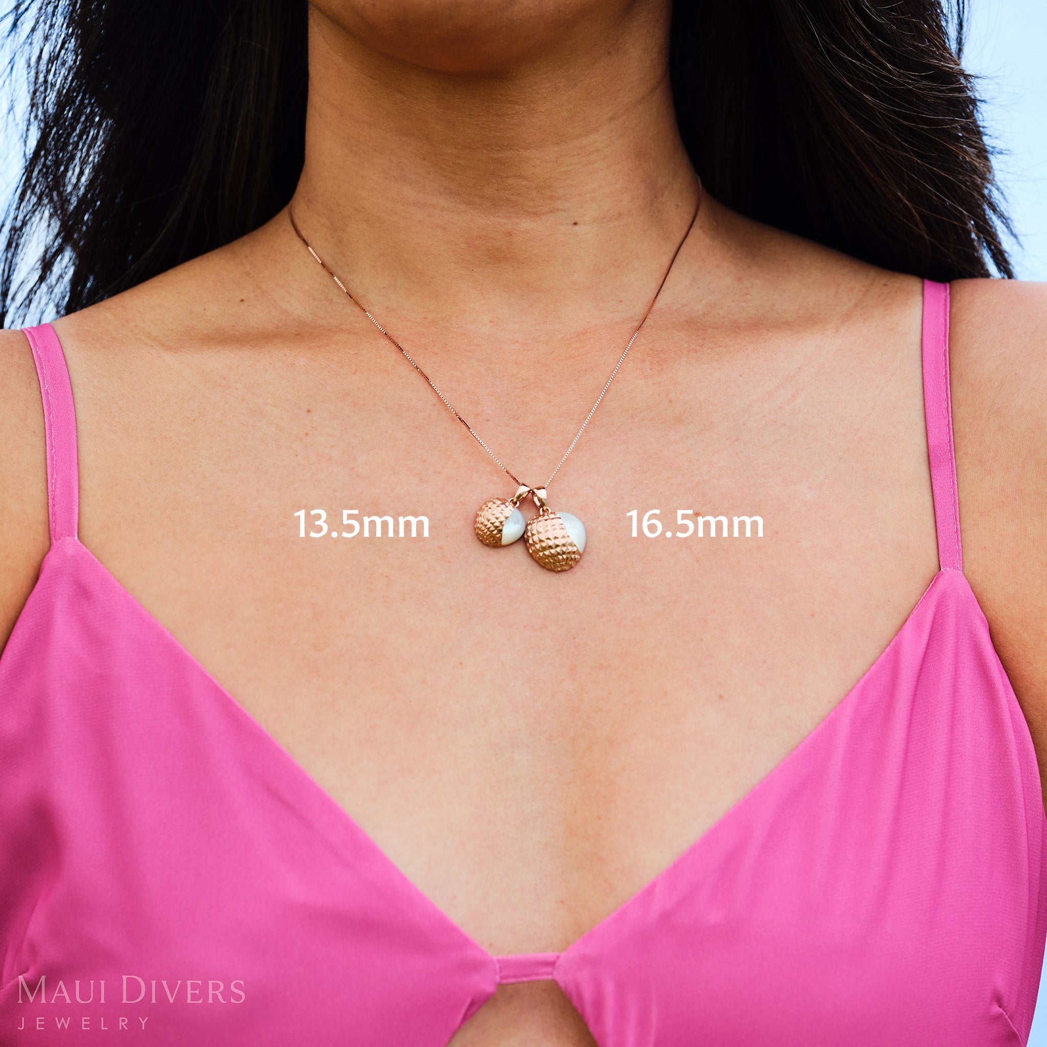 Woman in a pink top wearing a necklace with two Cute Fruits Lychee Mother of Pearl Pendants in 14k rose gold, labeled 13.5mm and 16.5mm.