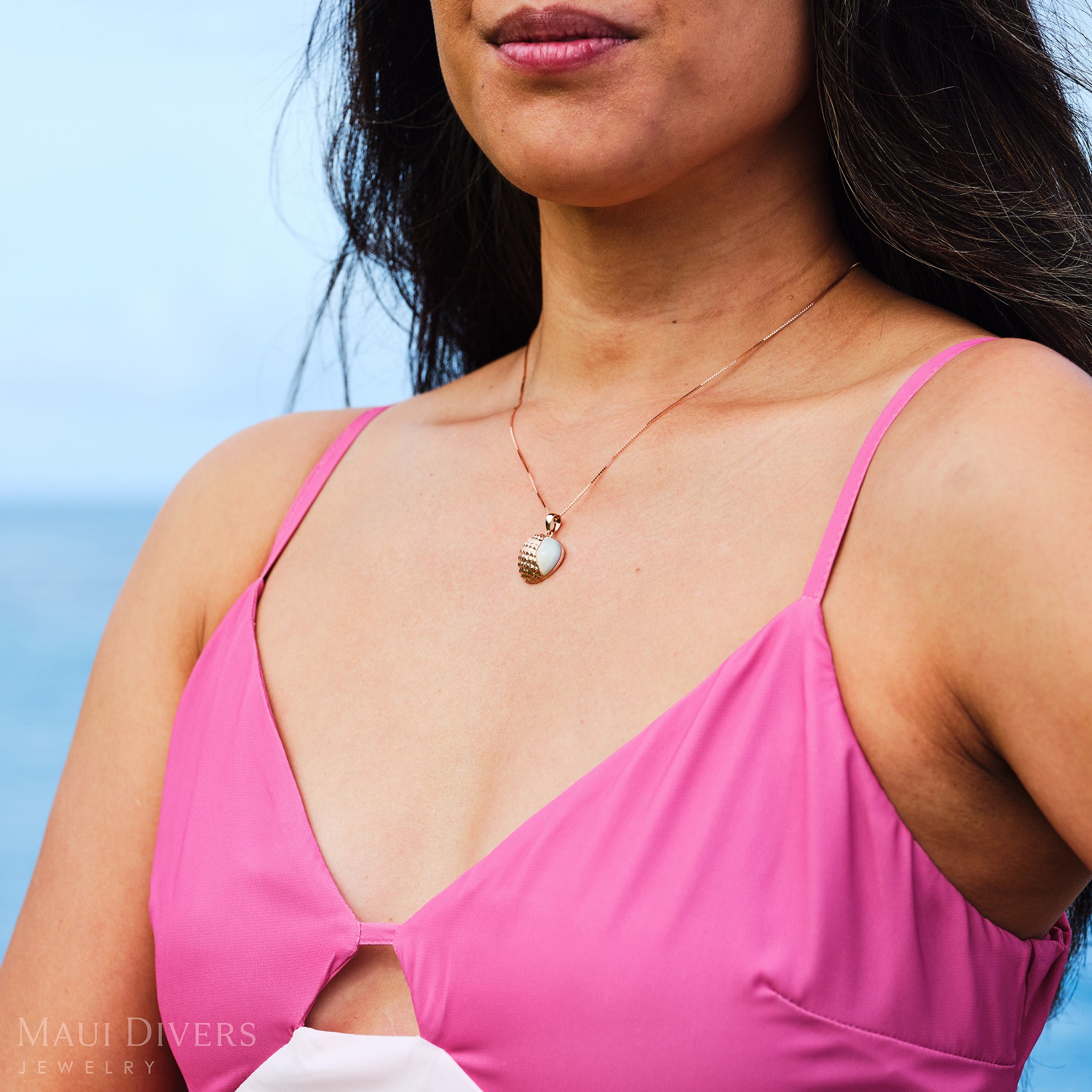 Close-up of a woman in a pink dress wearing a Cute Fruits Lychee Mother of Pearl Pendant in 14k rose gold around her neck