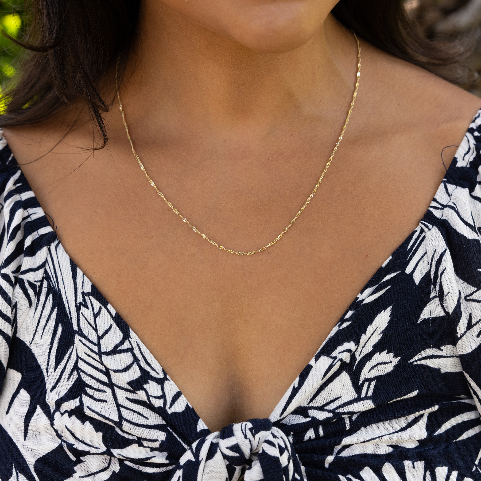 Close up of woman wearing 1.5mm Singapore Chain in Gold
