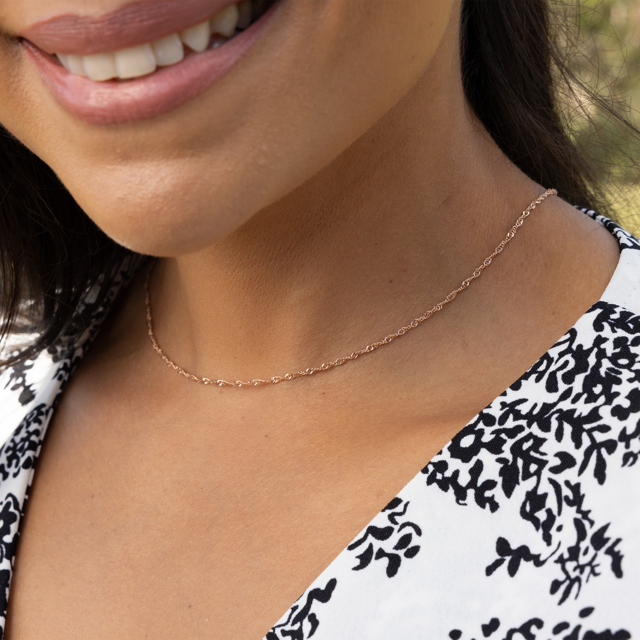 Close up of woman's neckline wearing 1.5mm Singapore Chain in Rose Gold