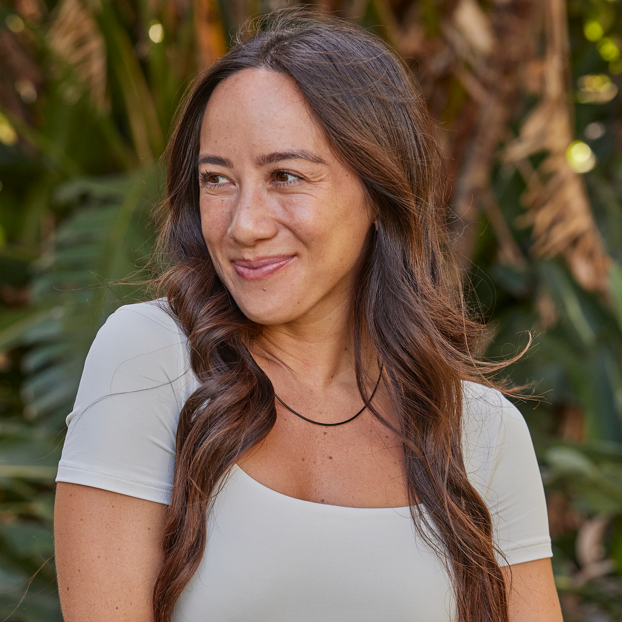 Woman in a tropical garden wearing a Black Rubber Cord Chain in Sterling Silver