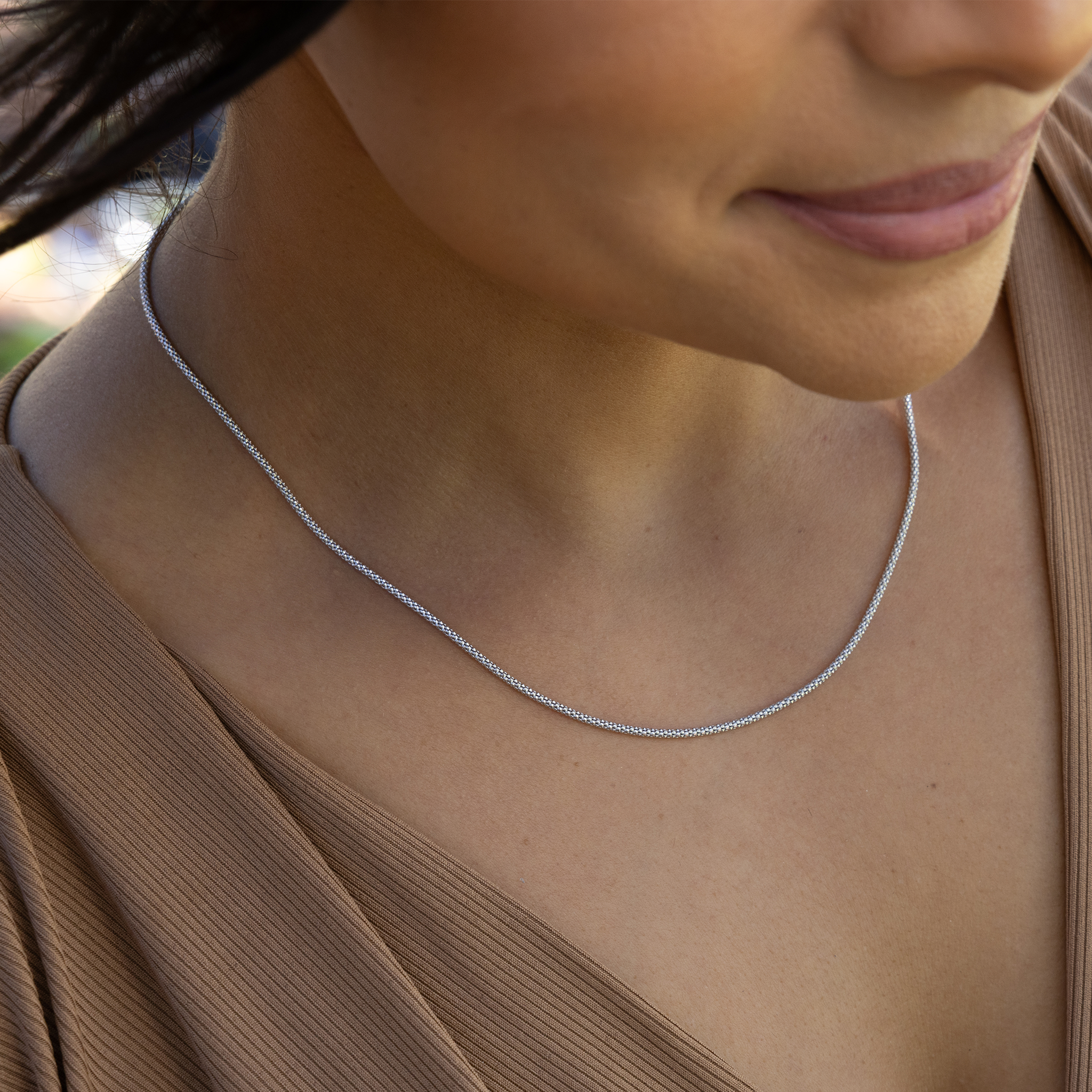 Close up of 1.5mm Popcorn Chain in Sterling Silver on a womanʻs chest