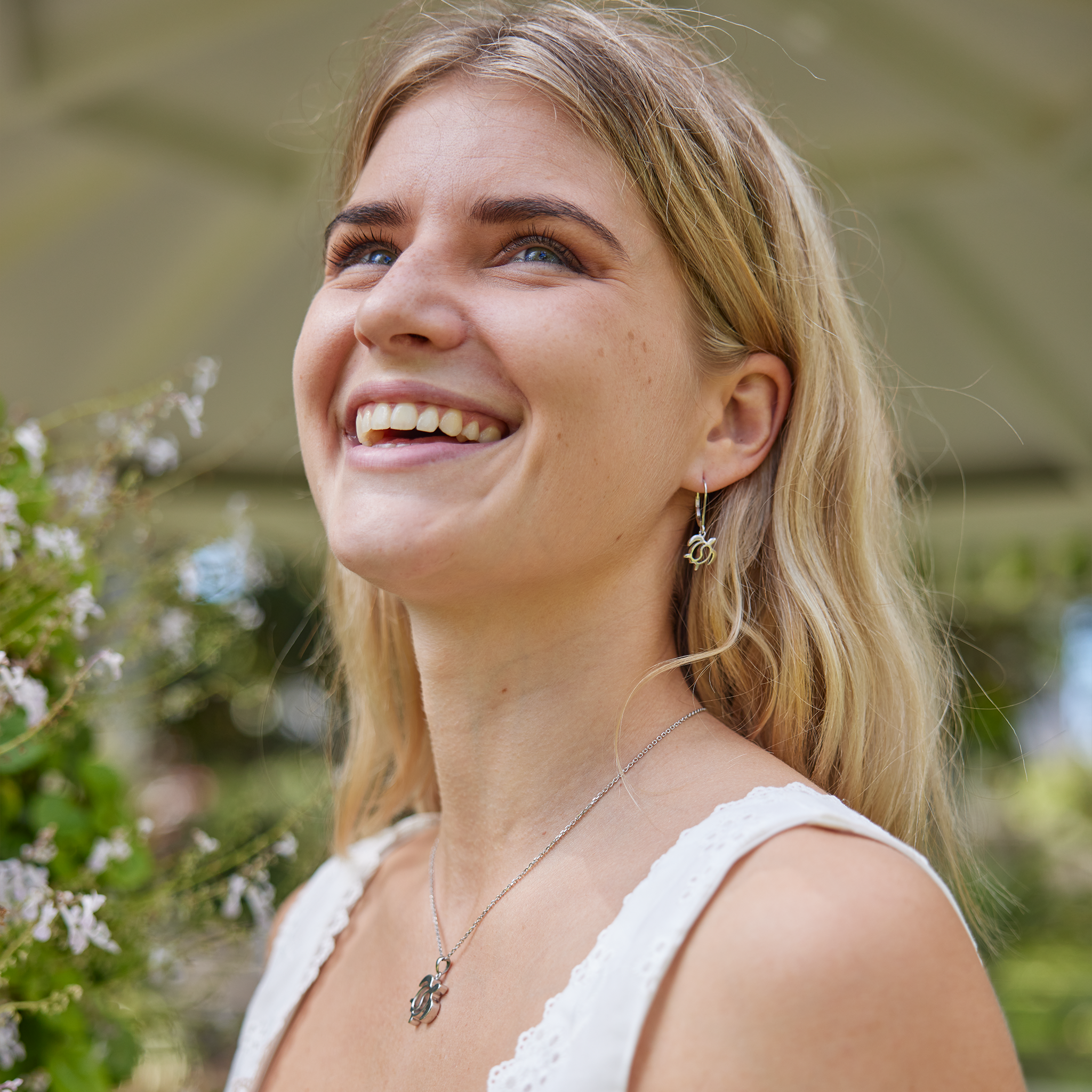 Woman in garden wearing honu yin yang set in sterling silver