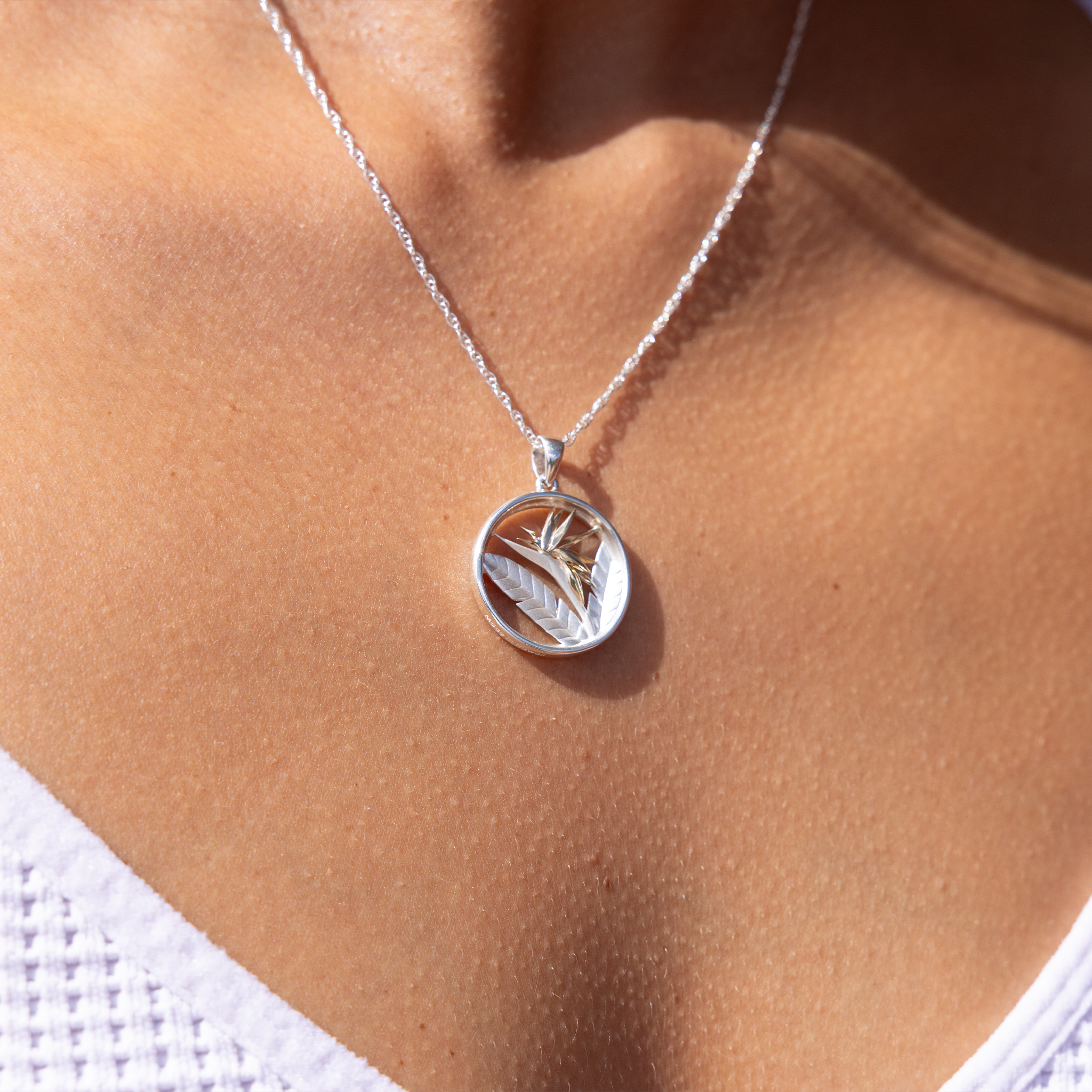 Close up of Birds of Paradise Pendant Necklace in Sterling Silver & Gold on a woman's chest