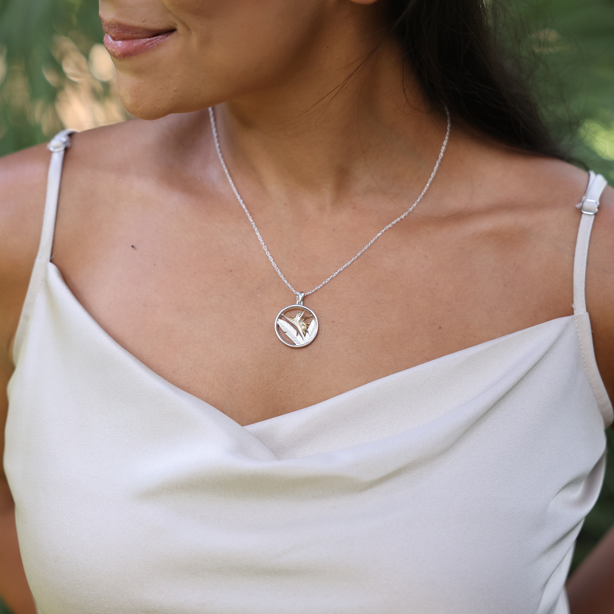 Woman wearing a white top and Birds of Paradise Pendant Necklace in Sterling Silver & Gold