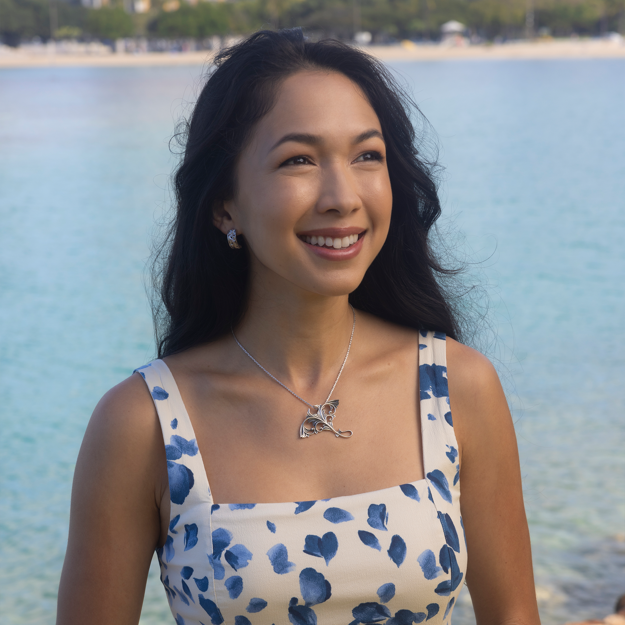 Woman by the ocean wearing a Living Heirloom Manta Ray Pendant in Sterling Silver