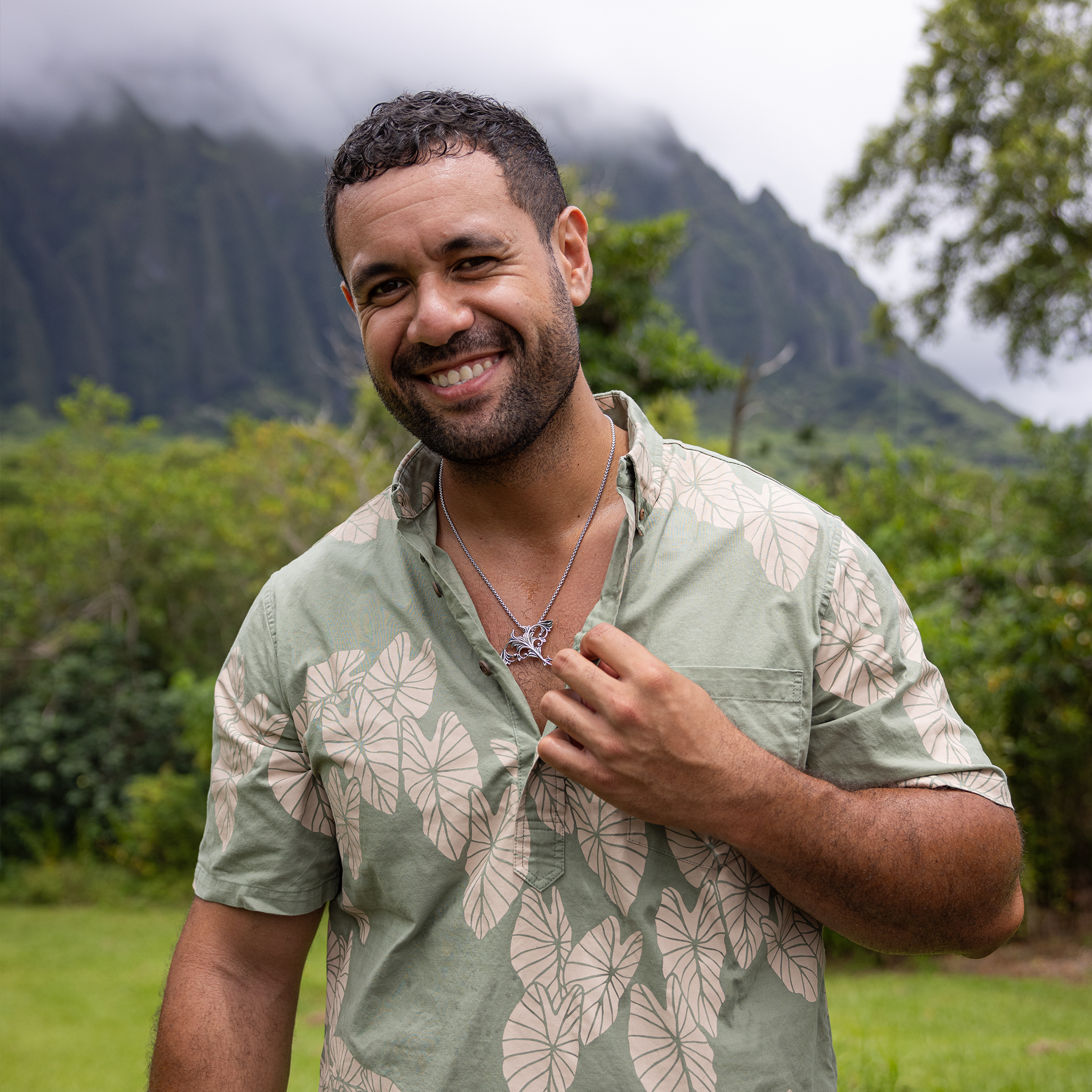 Man in a garden wearing a Living Heirloom Manta Ray Pendant in Sterling Silver and green shirt