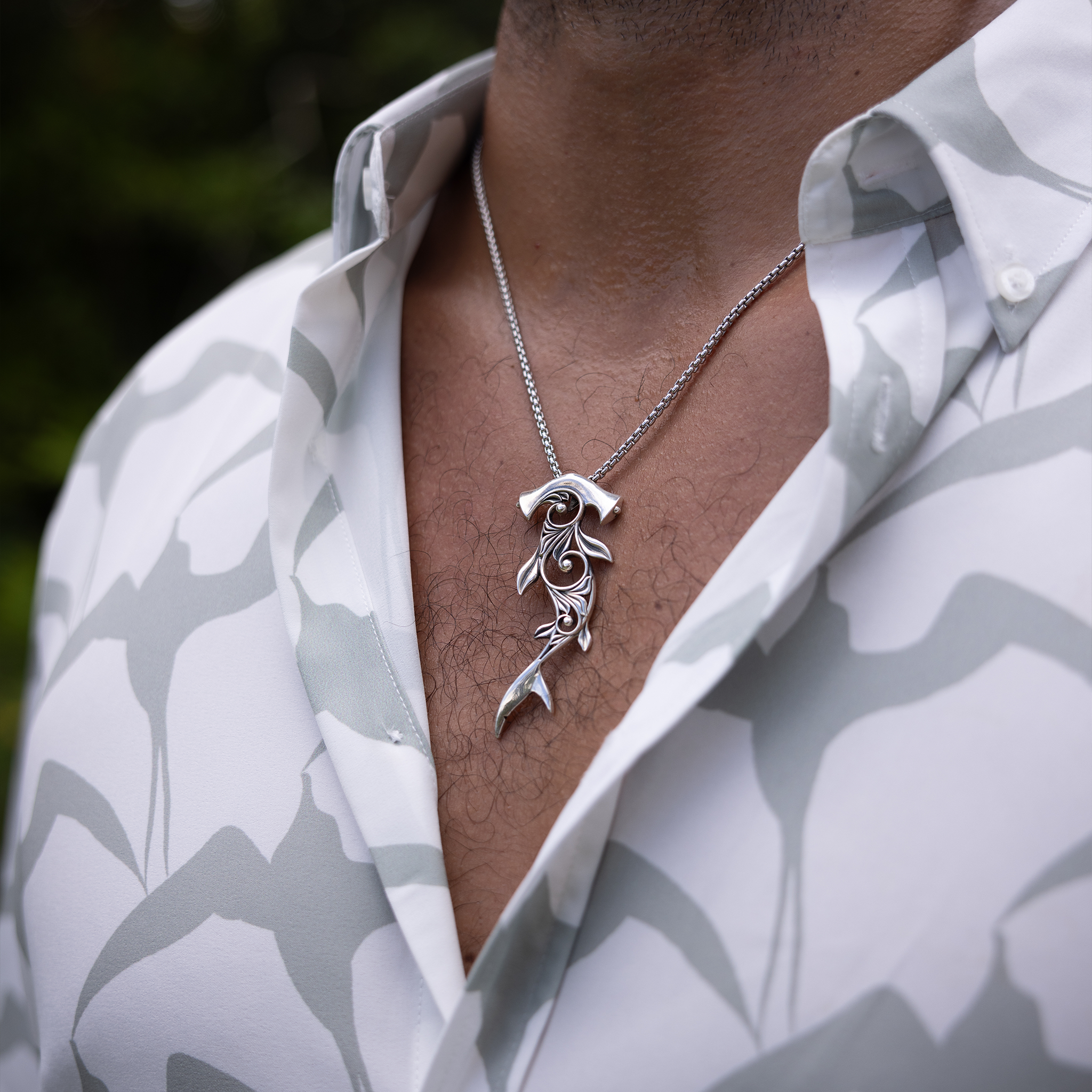 Close up of Living Heirloom Hammerhead Shark Pendant in Sterling Silver on a man's chest outdoors