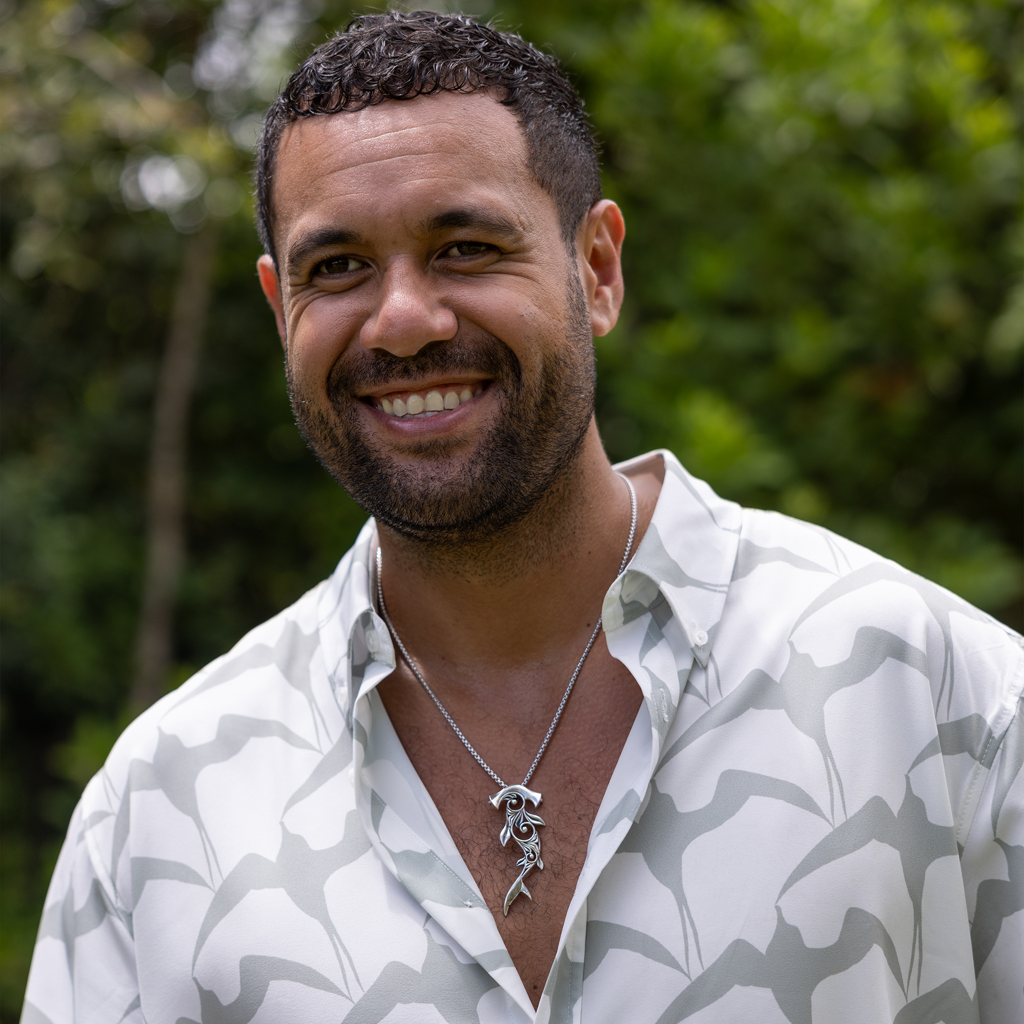 Man in a garden wearing a Living Heirloom Hammerhead Shark Pendant in Sterling Silver