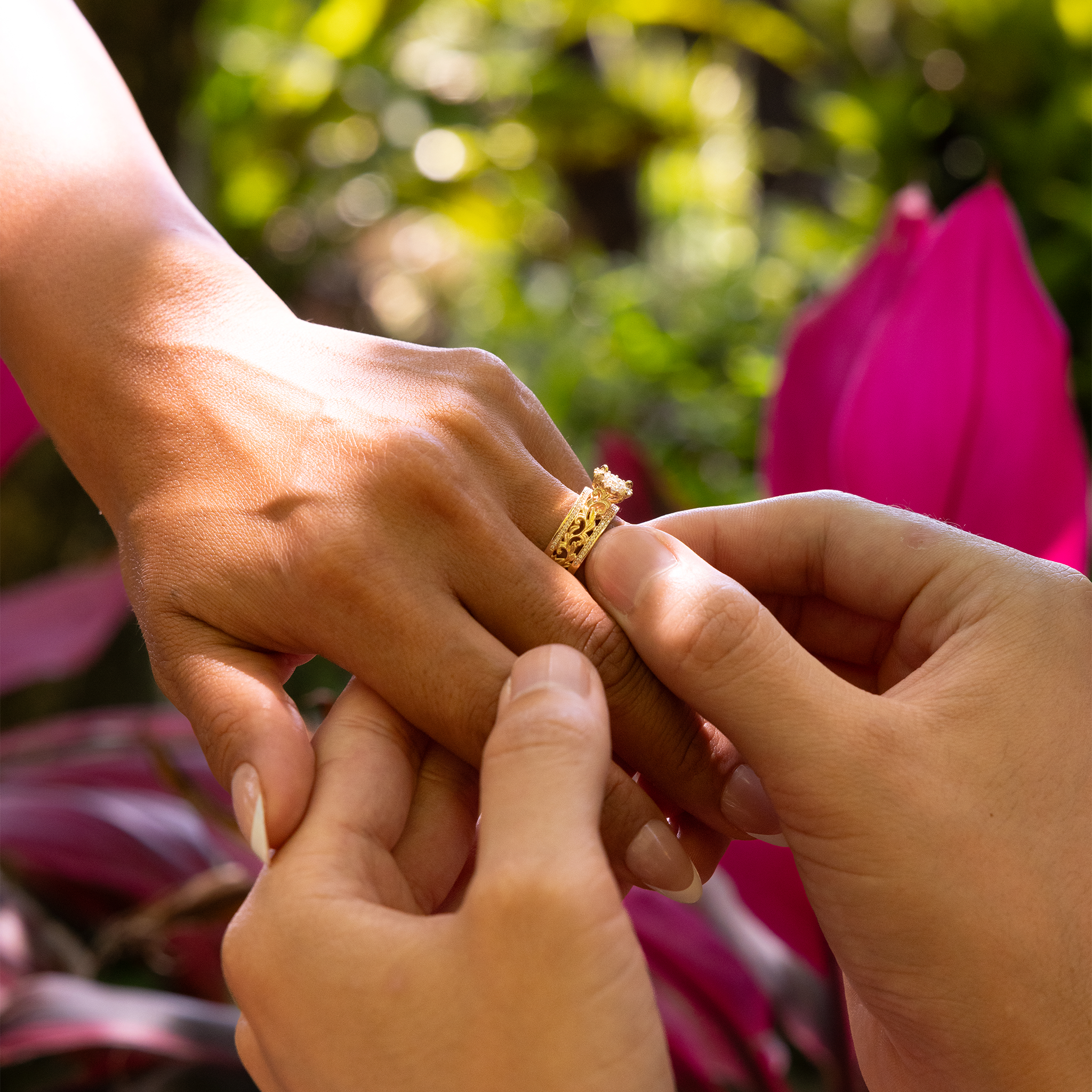 Person's hand placing a Living Heirloom Engagement Ring in Gold with Diamonds on another's finger