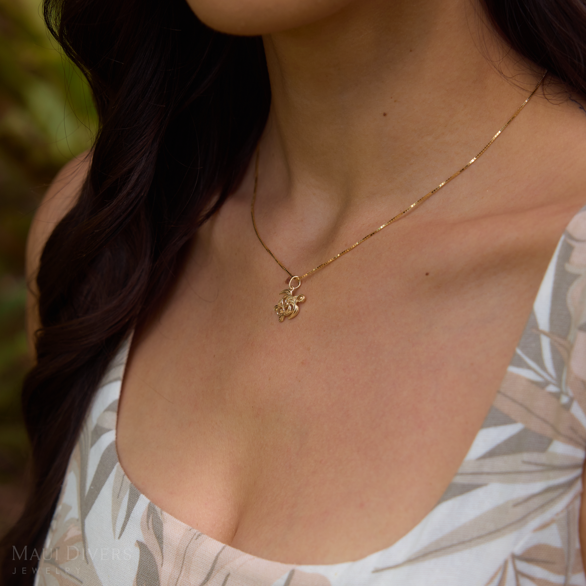 Woman wearing a Living Heirloom Honu Pendant in Gold outdoors