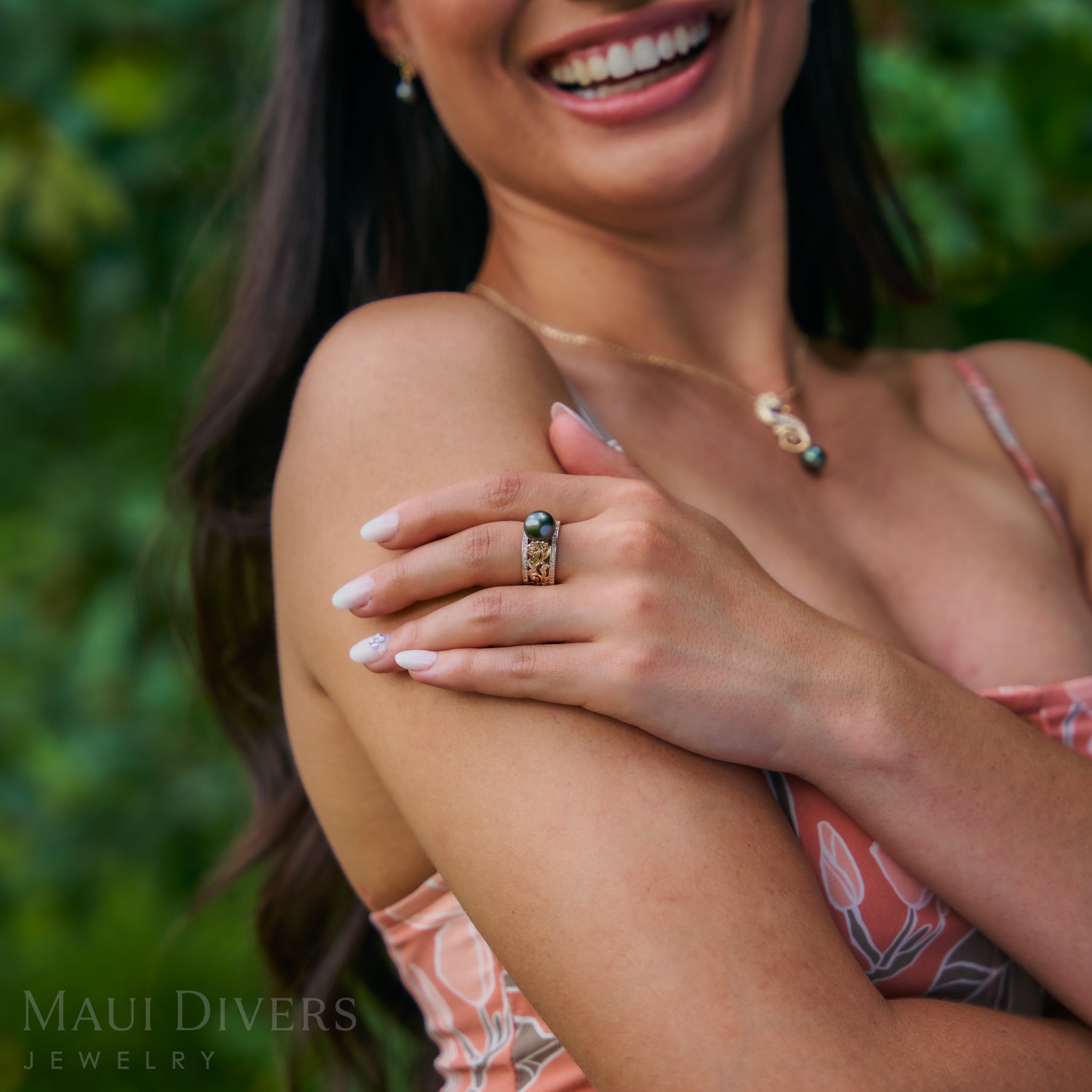 Woman wearing a Living Heirloom Tahitian Black Pearl Ring in Gold with Diamonds with leaves in the background