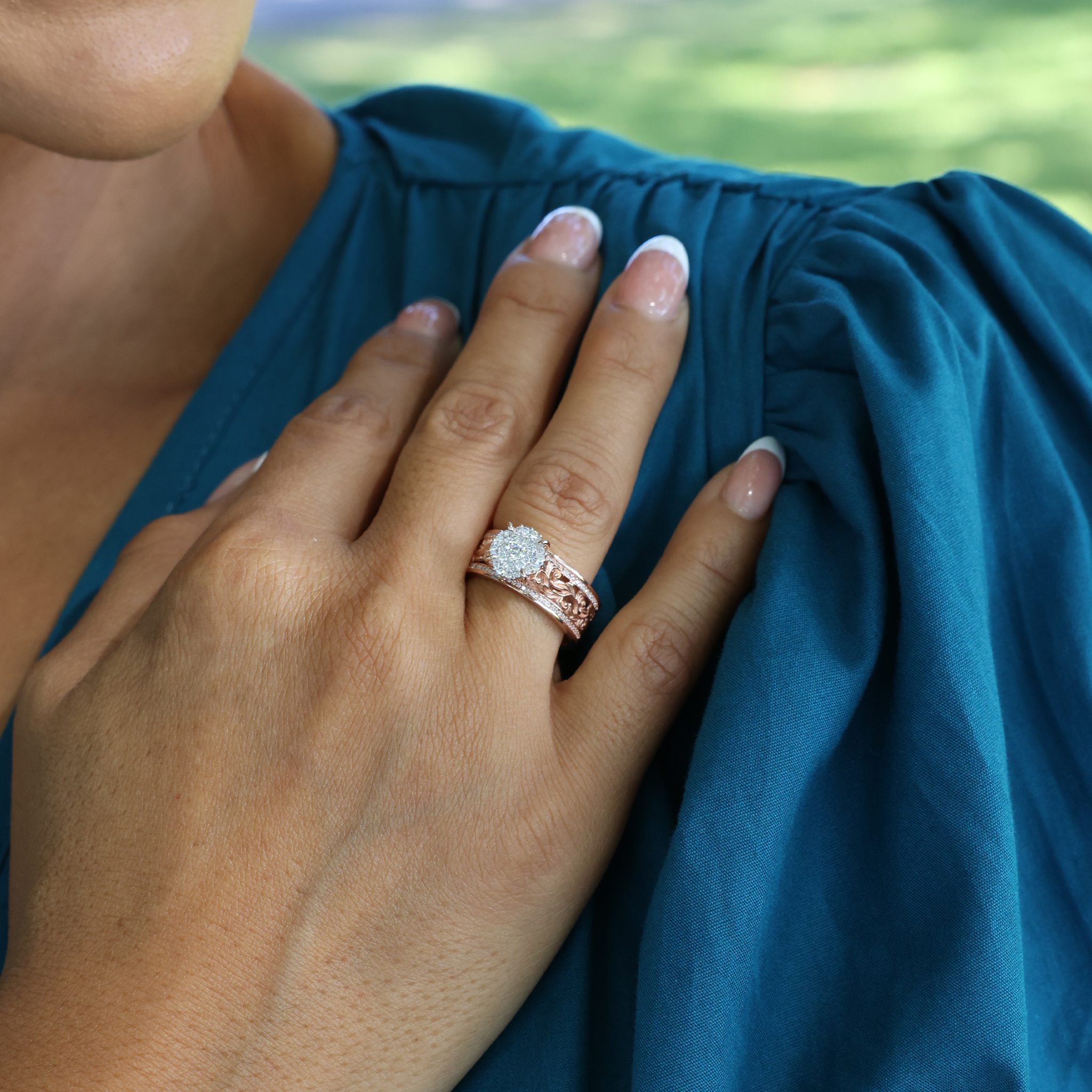 Close-up of a hand wearing a Living Heirloom Engagement Ring in Rose Gold with Diamonds resting on shoulder