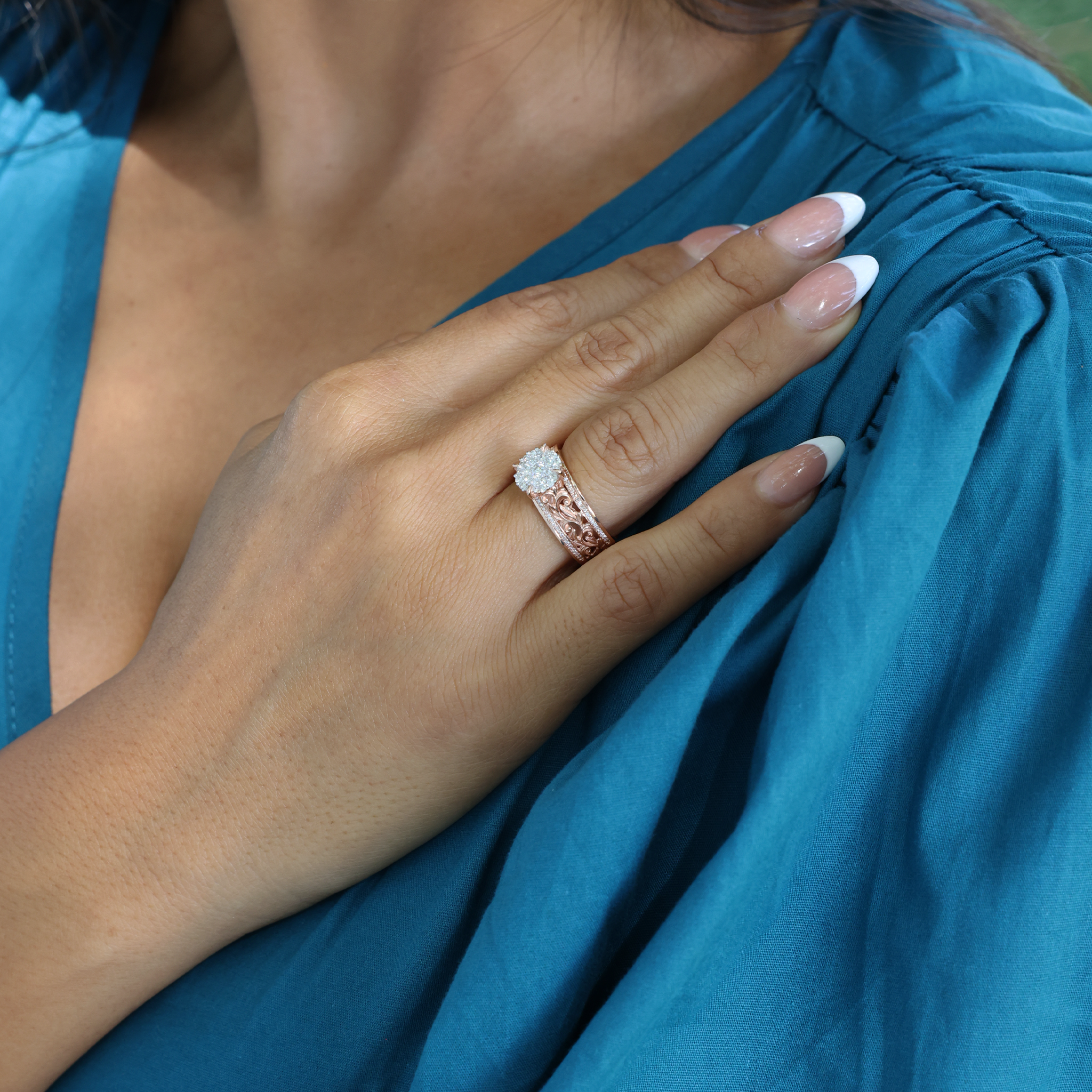 Close-up of a hand wearing a Living Heirloom Engagement Ring in Rose Gold with Diamonds resting on shoulder
