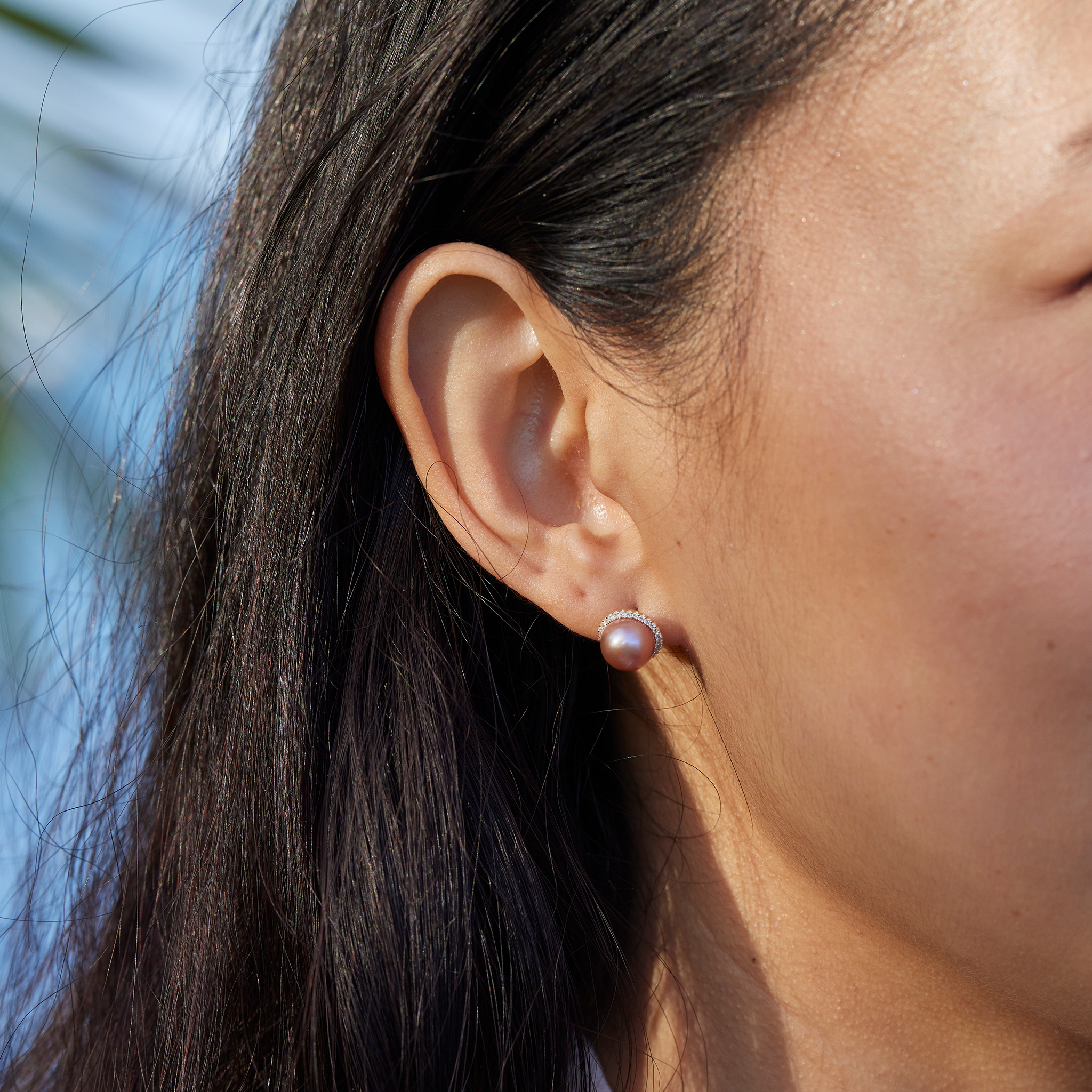 Close up of a woman's right ear and a Pick A Pearl Halo Earring in Gold with Diamonds and Lavender Pearl