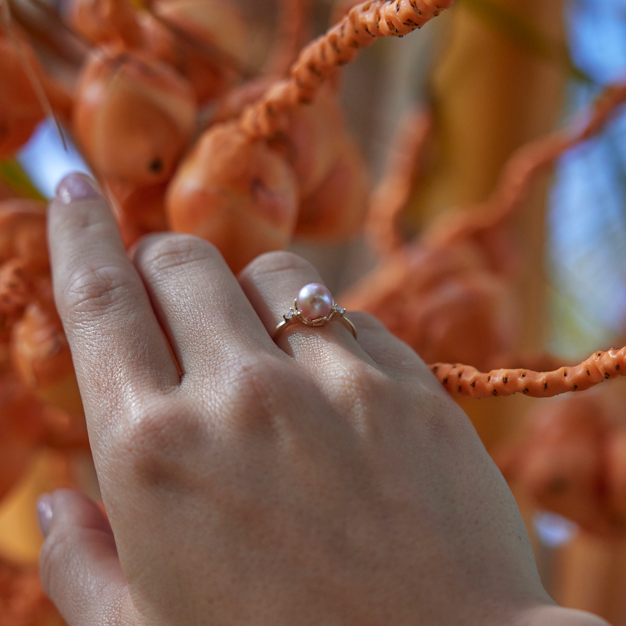 Pick A Pearl Crown Ring in Gold with Diamonds and a Pink Pearl on a hand with natural background
