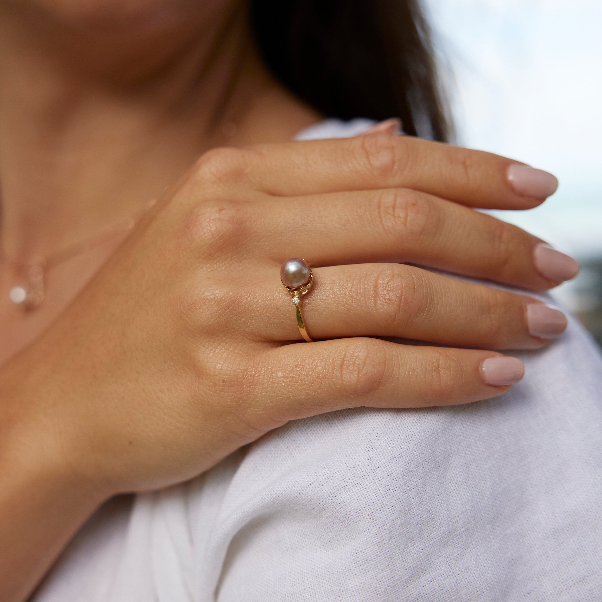 Pick A Pearl Crown Ring in Gold with Diamonds and a Lavender Pearl on a woman's hand resting on her shoulder