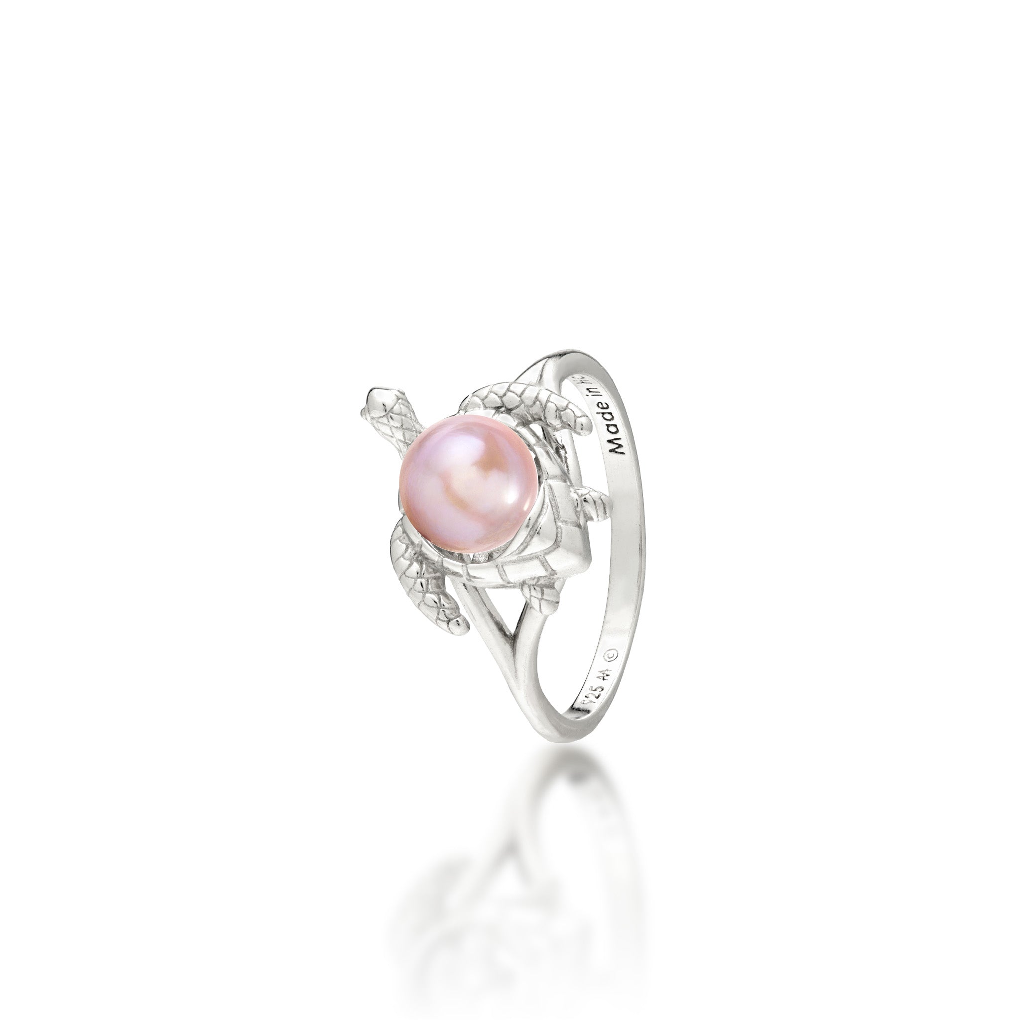A sterling silver ring featuring a central lavender freshwater pearl set on a Hawaiian green sea turtle's back, on a white background with a soft reflection.