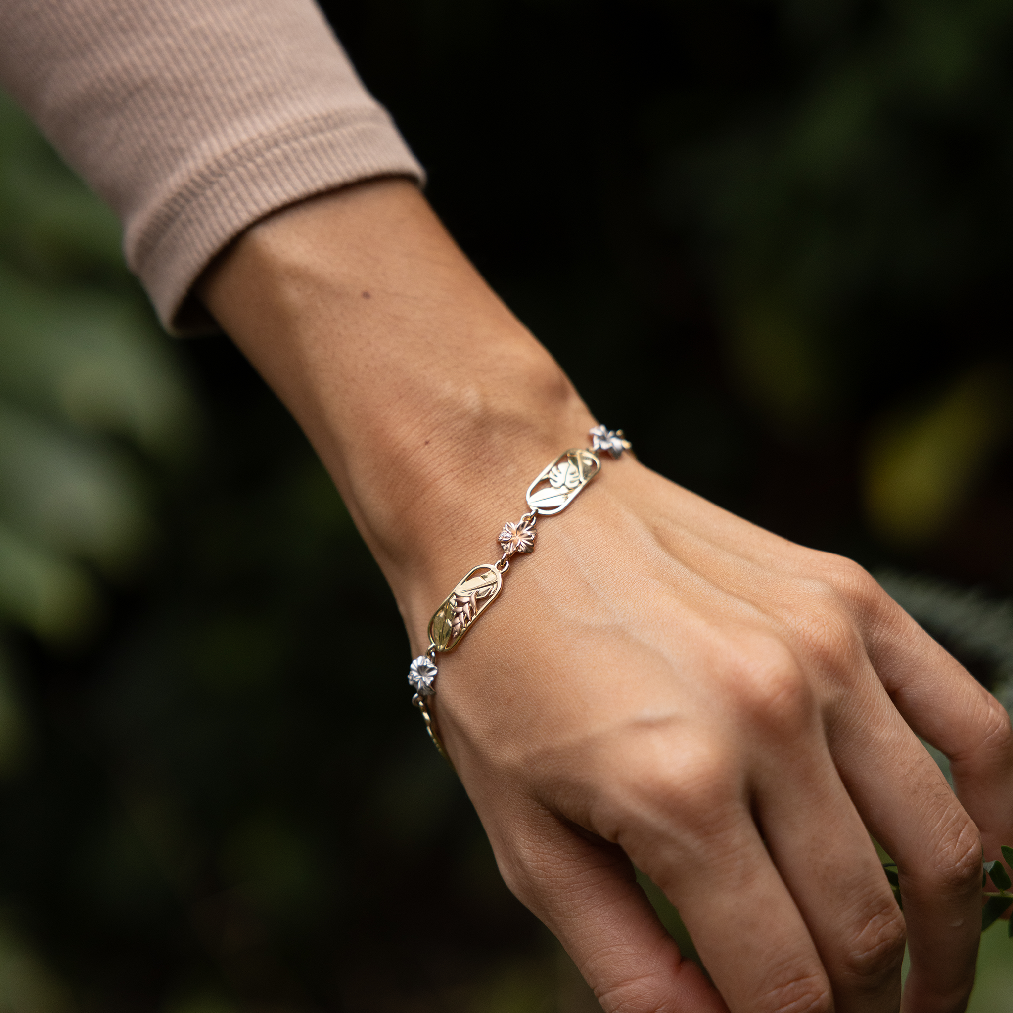 Hawaiian Gardens Link Bracelet in Yellow, White, Rose and Green Gold with Diamonds on wrist in a garden