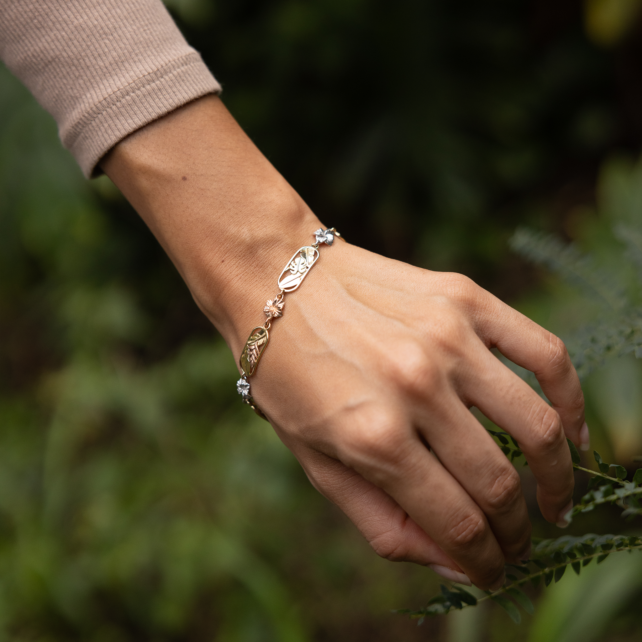 Hawaiian Gardens Link Bracelet in Yellow, White, Rose and Green Gold with Diamonds on wrist in a garden