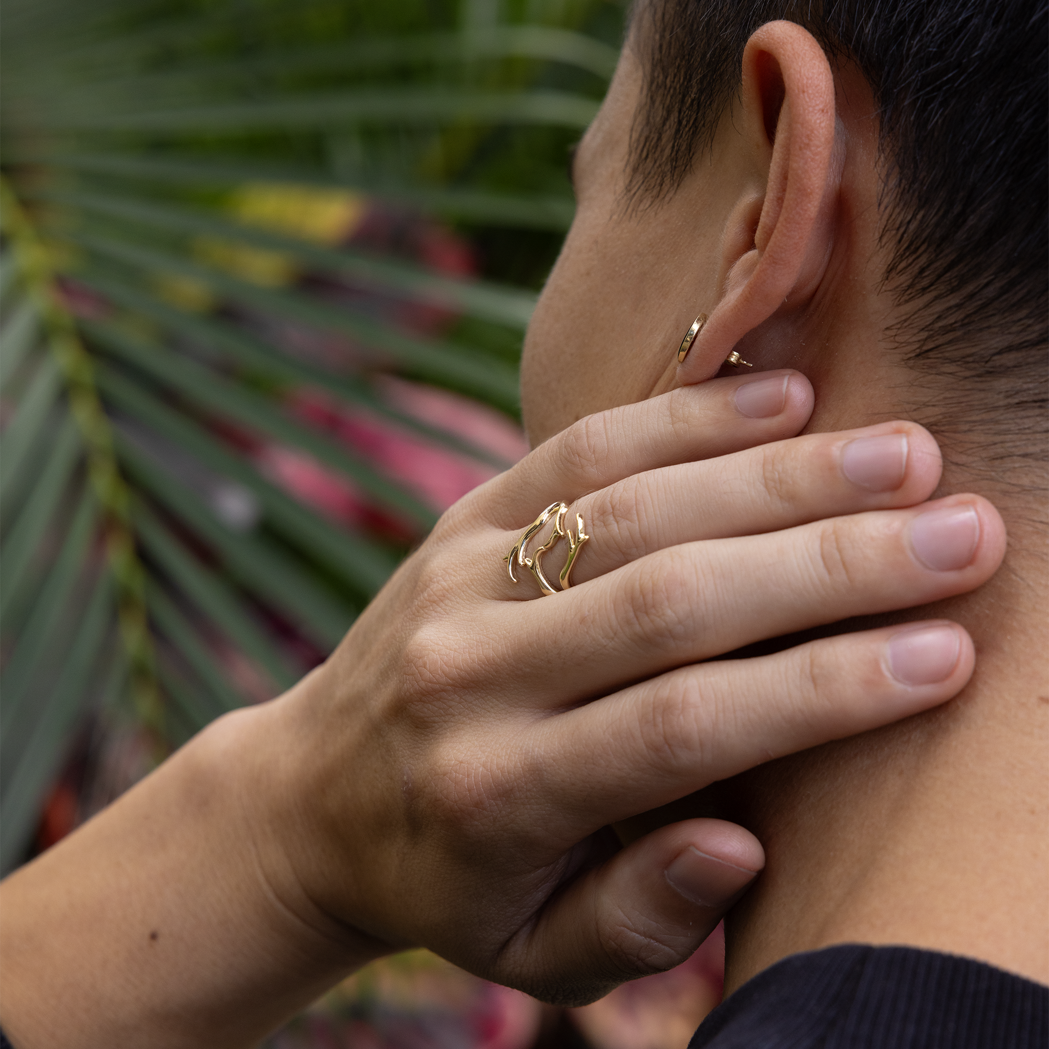 Close up of Heritage Coral Branch Ring in Gold on a man's hand resting on his neck