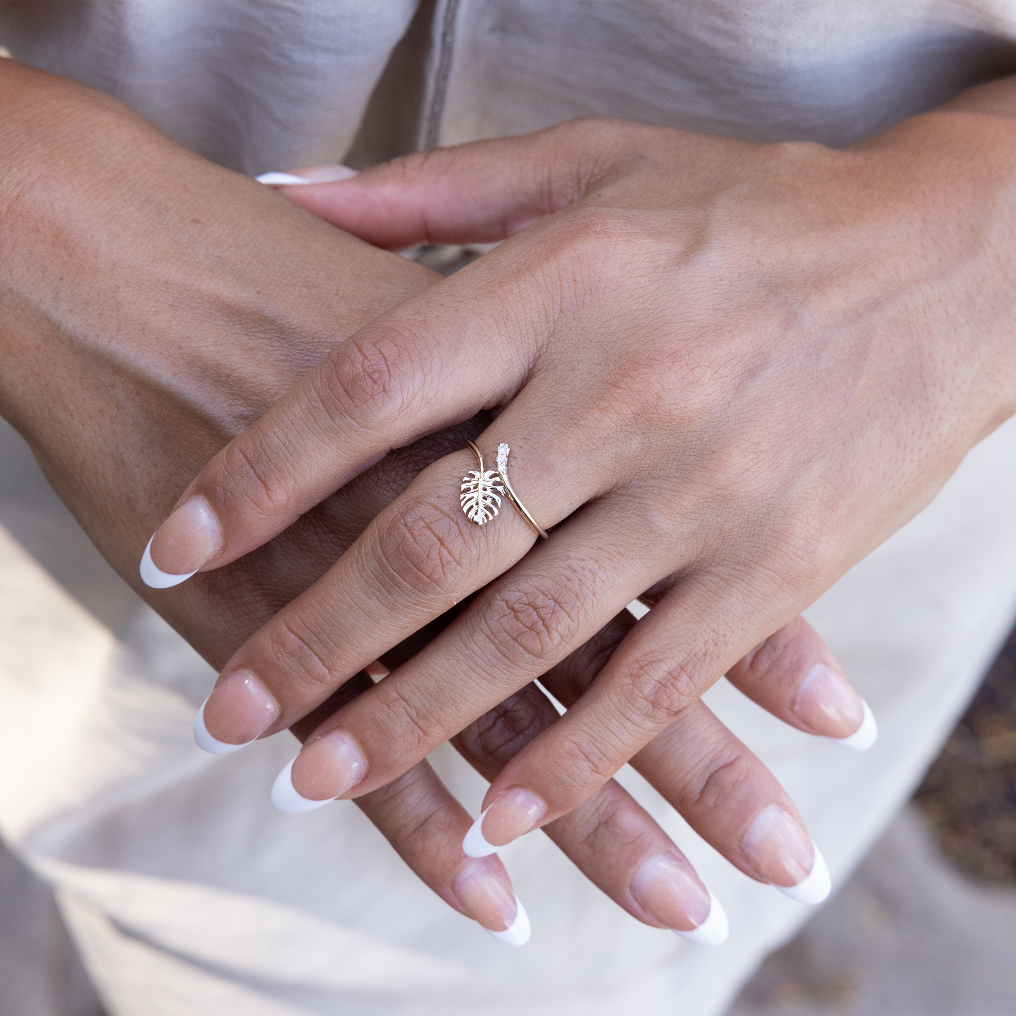 Close up of a 9mm Monstera Ring in Gold with Diamonds on woman's hands