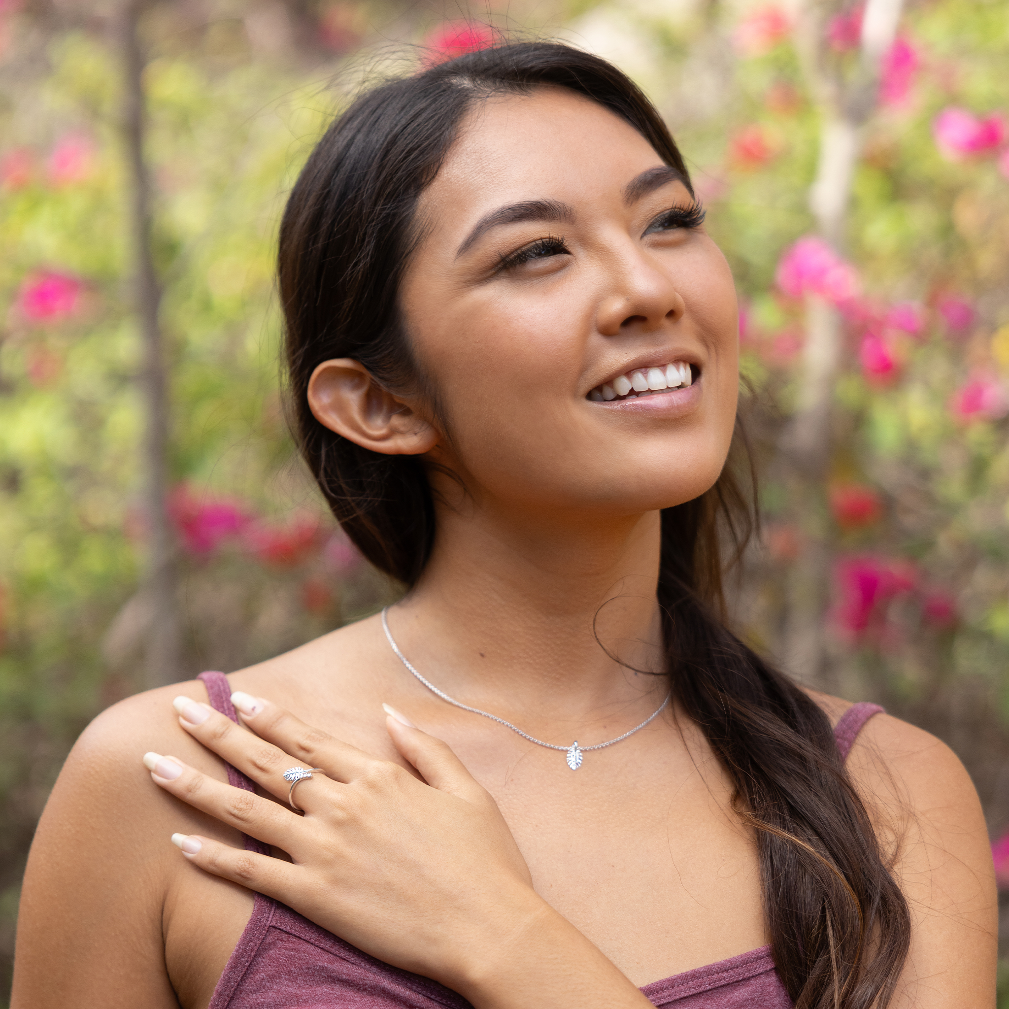 Woman in a garden wearing a 9mm Monstera Ring and Pendant in White Gold with Diamonds