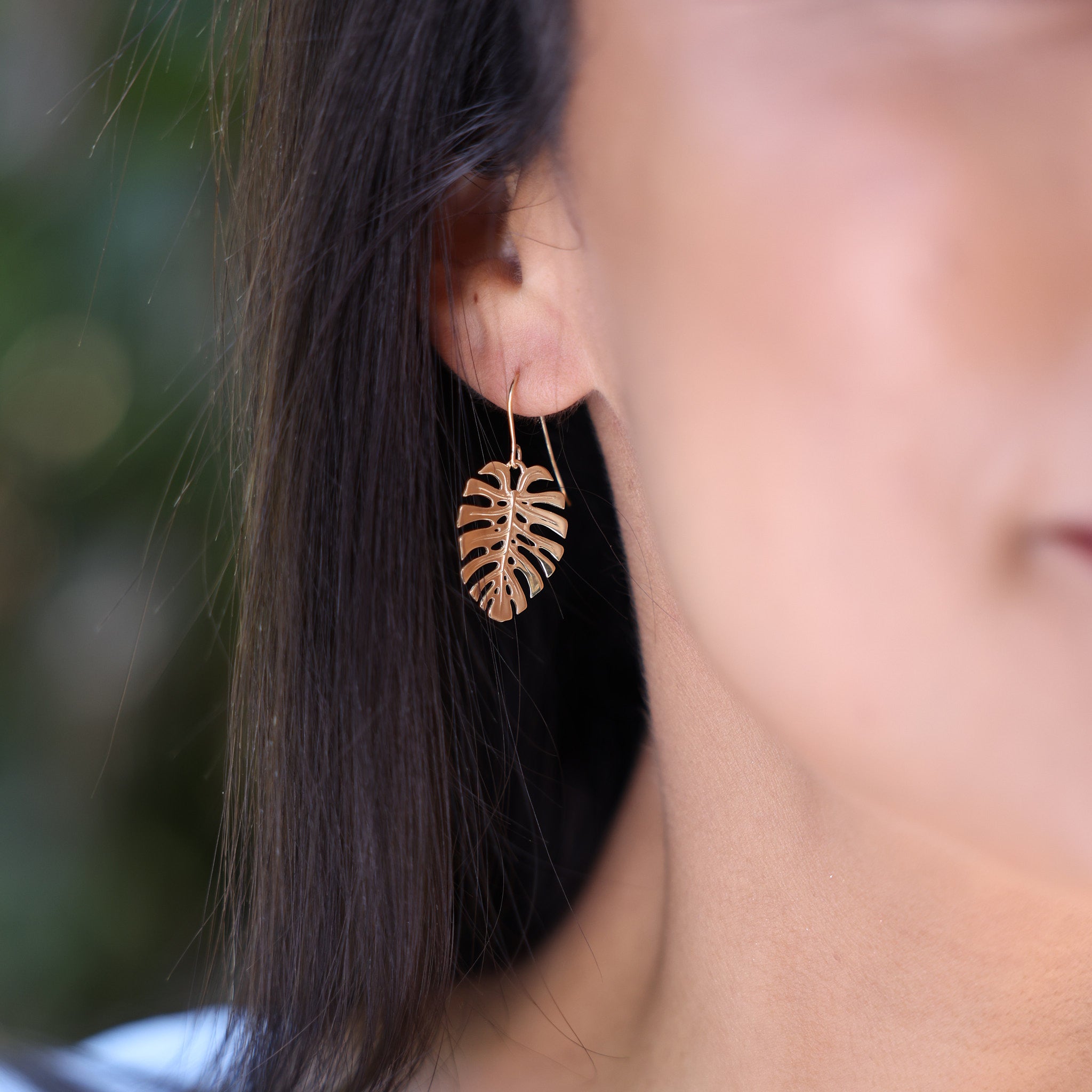 Close up of woman wearing 23mm Monstera Earrings in Rose Gold