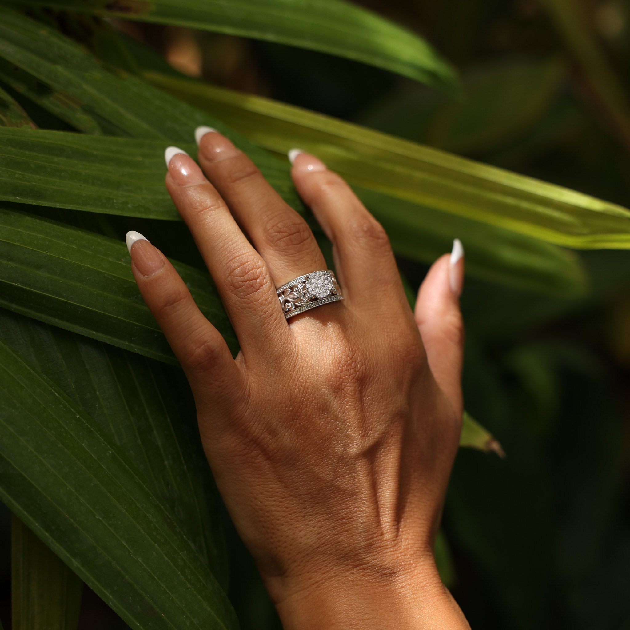 Living Heirloom Engagement Ring in White Gold with Diamonds on woman's hand with tropical forest background