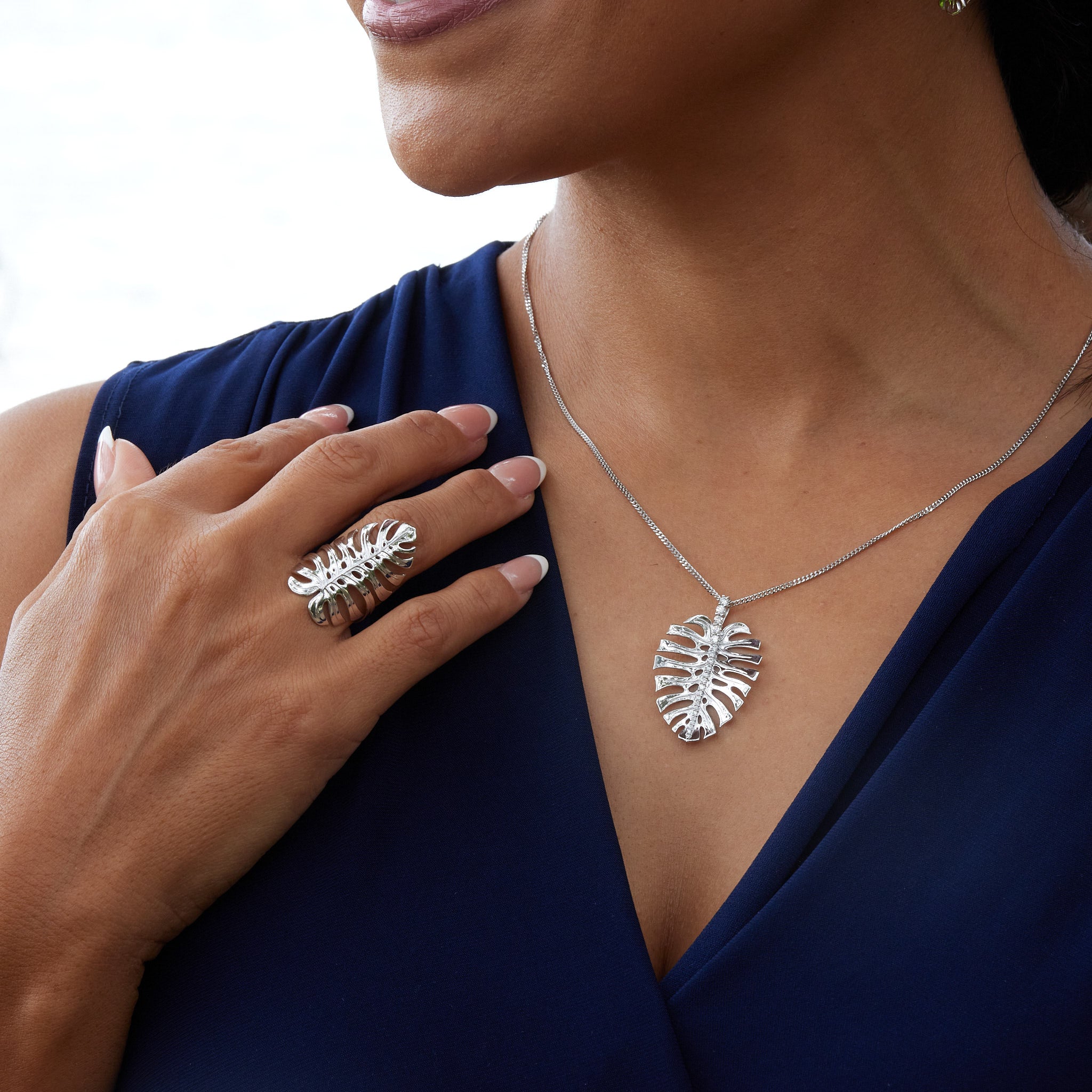 A woman wearing a Monstera Ring and Pendant in White Gold