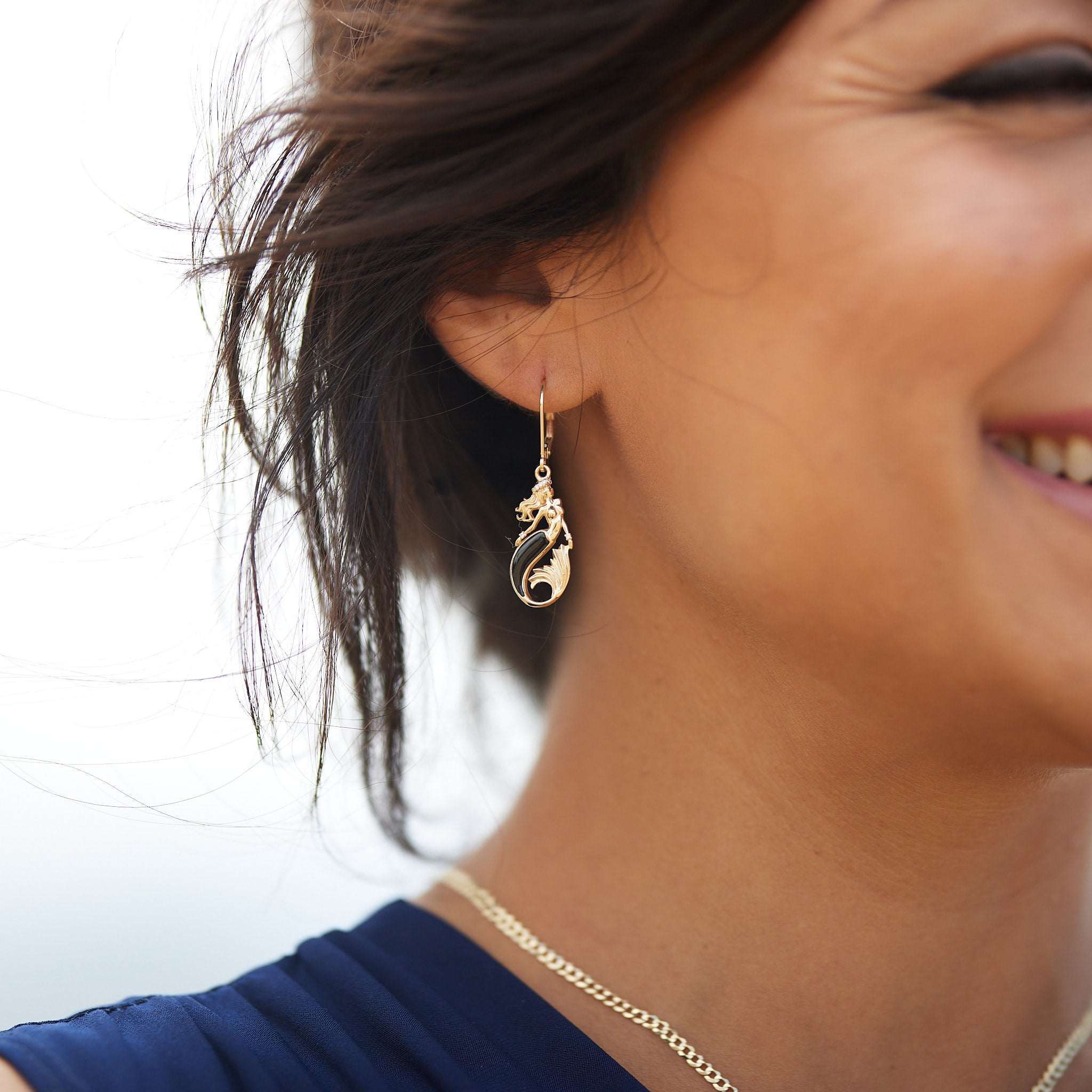 A womanʻs ear with Sealife Mermaid Black Coral Earrings in Gold with Diamonds - 24mm - Maui Divers Jewelry