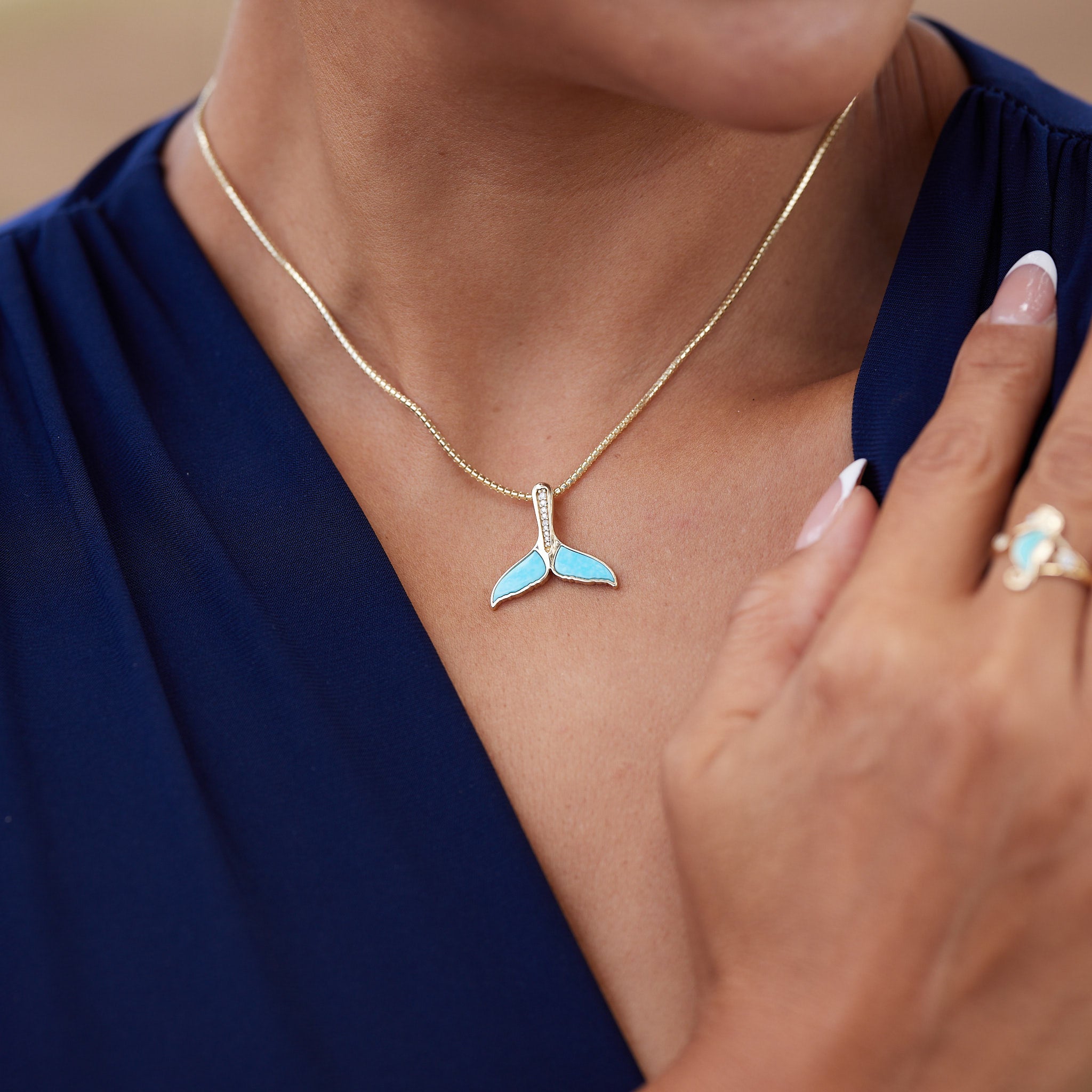 A woman's chest with a Sealife Whale Tail Turquoise Pendant in gold with Diamonds - 22mm - Maui Divers Jewelry