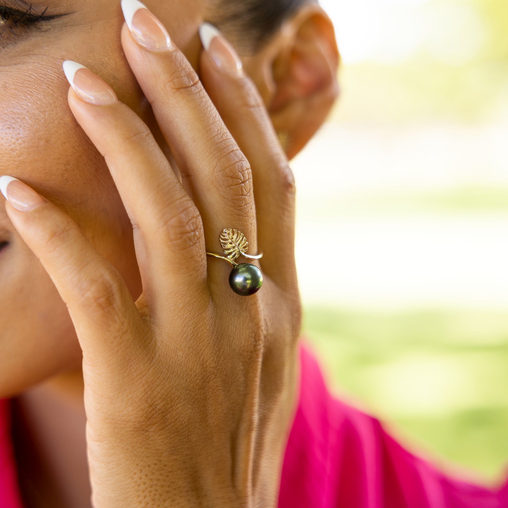 A woman's hand wearing a Monstera Tahitian Black Pearl Ring in Gold - Maui Divers Jewelry