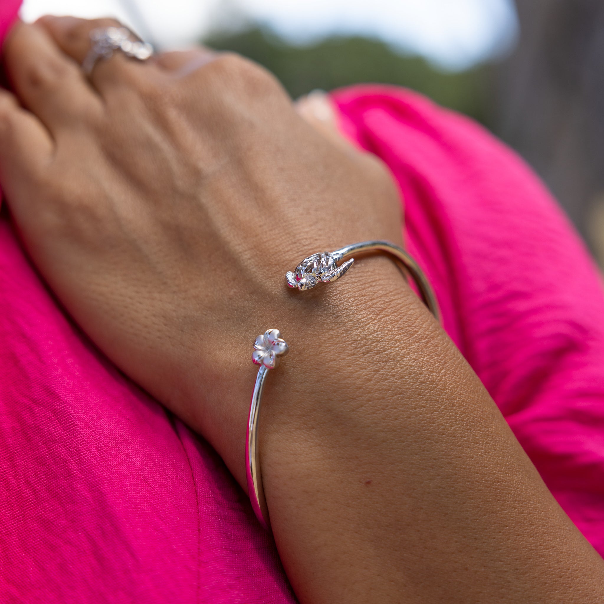A woman's hand with a Honu and Plumeria Bracelet in Sterling Silver-Maui Divers Jewelry